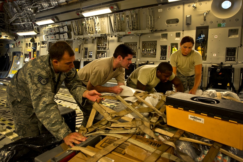 Staff Sgt. Kyle Pratt, Senior Airman Timothy Wochnick, Staff Sgt. Ralph Miller, and Staff Sgt. Sharon Clark, aircrew flight equipment technicians with the 437th Operations Support Squadron out of Joint Base Charleston - Air Base, S.C, strap down the alert kit on a C-17A Globemaster III, June 8, 2012. The Airmen swap out and inspect equipment for C-17A alert aircraft on standby every 30 days. (U.S. Air Force photo by Airman 1st Class George Goslin/Released)