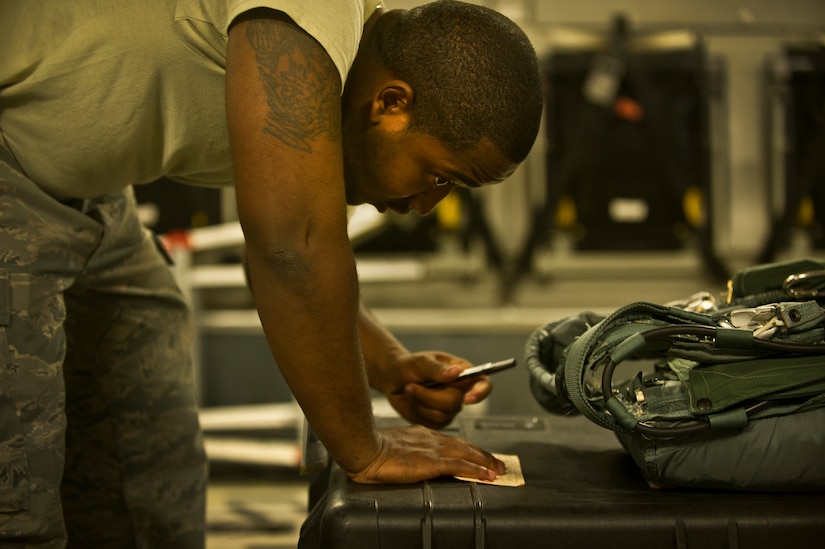 Staff Sgt. Ralph Miller, an aircrew flight equipment technician with the 437th Operations Support Squadron out of Joint Base Charleston - Air Base, S.C, updates the expiration dates on parachutes on a C-17 Globemaster III, June 8, 2012. The Airmen swap out and inspect equipment for C-17A alert aircraft on standby every 30 days. (U.S. Air Force photo by Airman 1st Class George Goslin/Released)