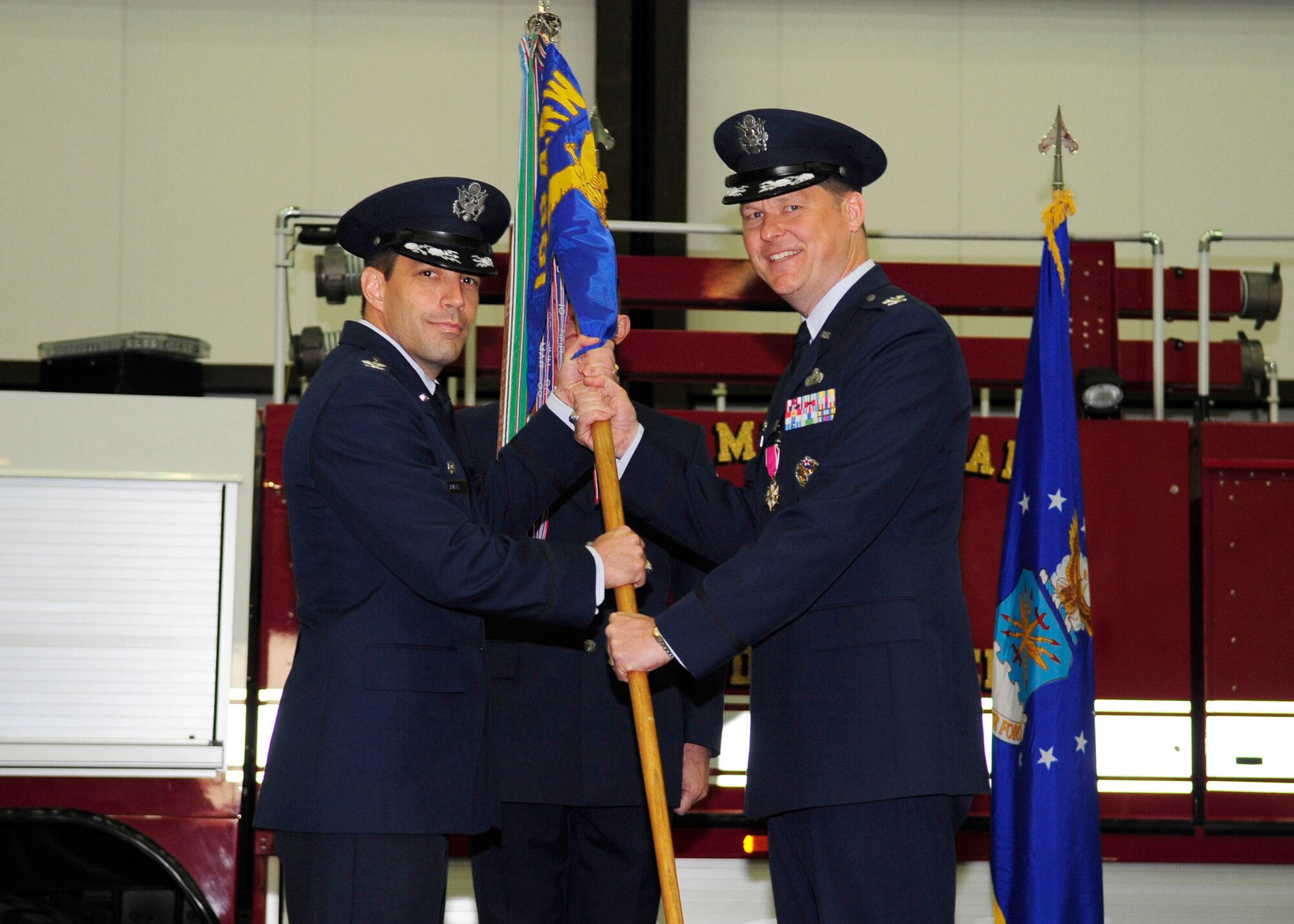 RAF MILDENHALL, England -- Col. David Doe, (right) 100th Mission Group commander, passes the 100th MSG's guidon to Col. Christopher Kulas, 100th Air Refueling Wing commander, during the 100th MSG change of command here June 13, 2012. Col. Doe passed off the guidon to symbolize him relinquishing command of the 100th MSG. (U.S. Air Force photo/Senior Airman Ethan Morgan)