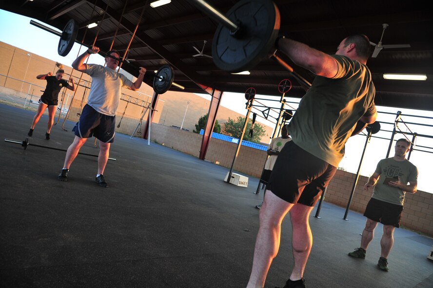 A Crossfit group performs various exercises at the combat fitness pad at Cannon Air Force Base, N.M., June 11, 2012. Crossfit establishes broad general fitness across many versus specialization in one certain area of the body. (U.S. Air Force photo by Airman 1st Class Xavier Lockley)