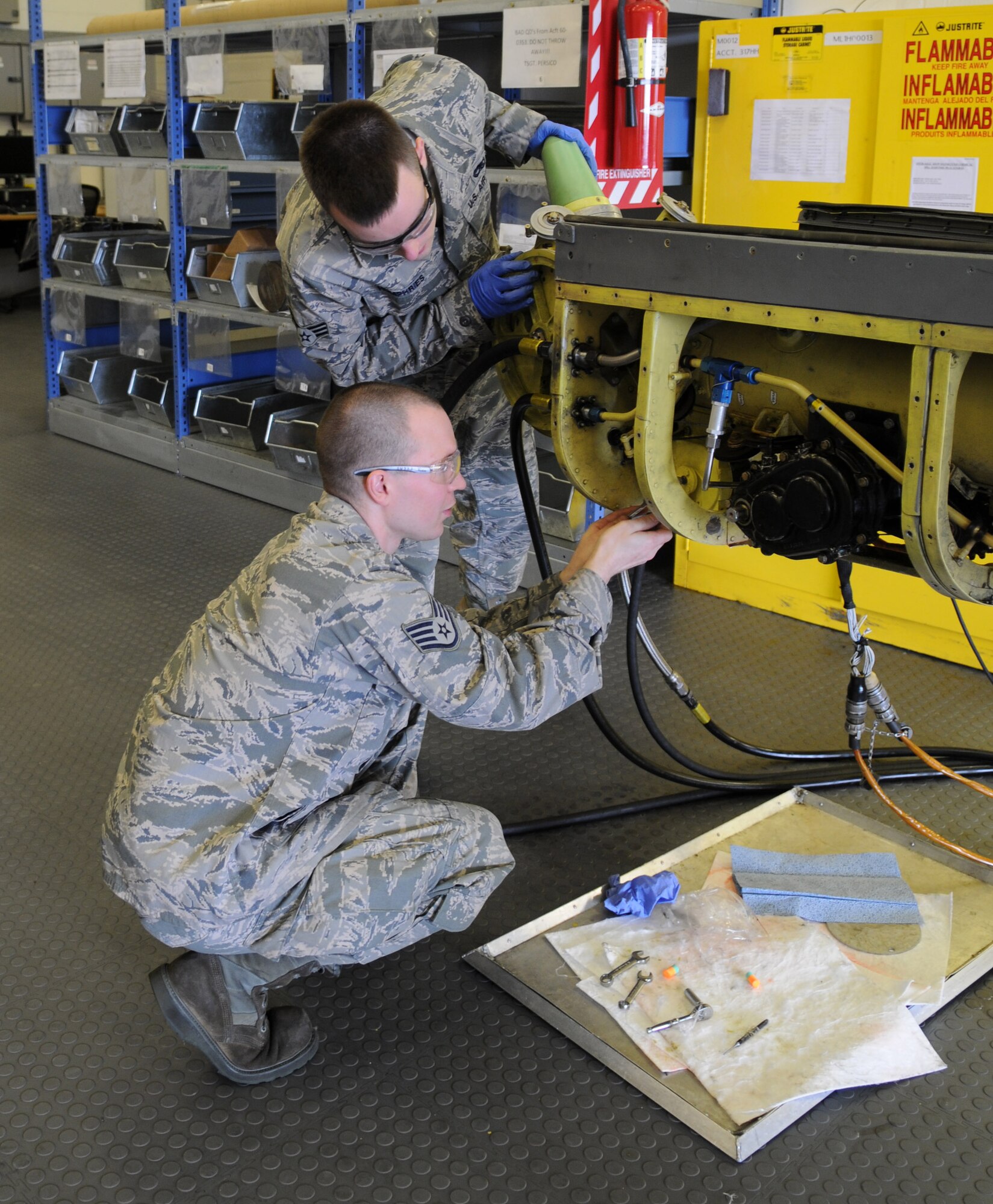 RAF MILDENHALL, England – Staff Sgt. Marcus Lake, 100th Maintenance Squadron aircraft hydraulics journeyman, tightens a screw to calibrate the elevation transmitter on a KC-135 Stratotanker boom June 12, 2012, in the hydraulics shop here, as Senior Airman Ethan Humphries, 100th MXS aircraft hydraulics journeyman, observes. The transmitter reports to the boom operator the angle the boom is from the aircraft during refueling. (U.S. Air Force photo/Senior Airman Rachel Waller)