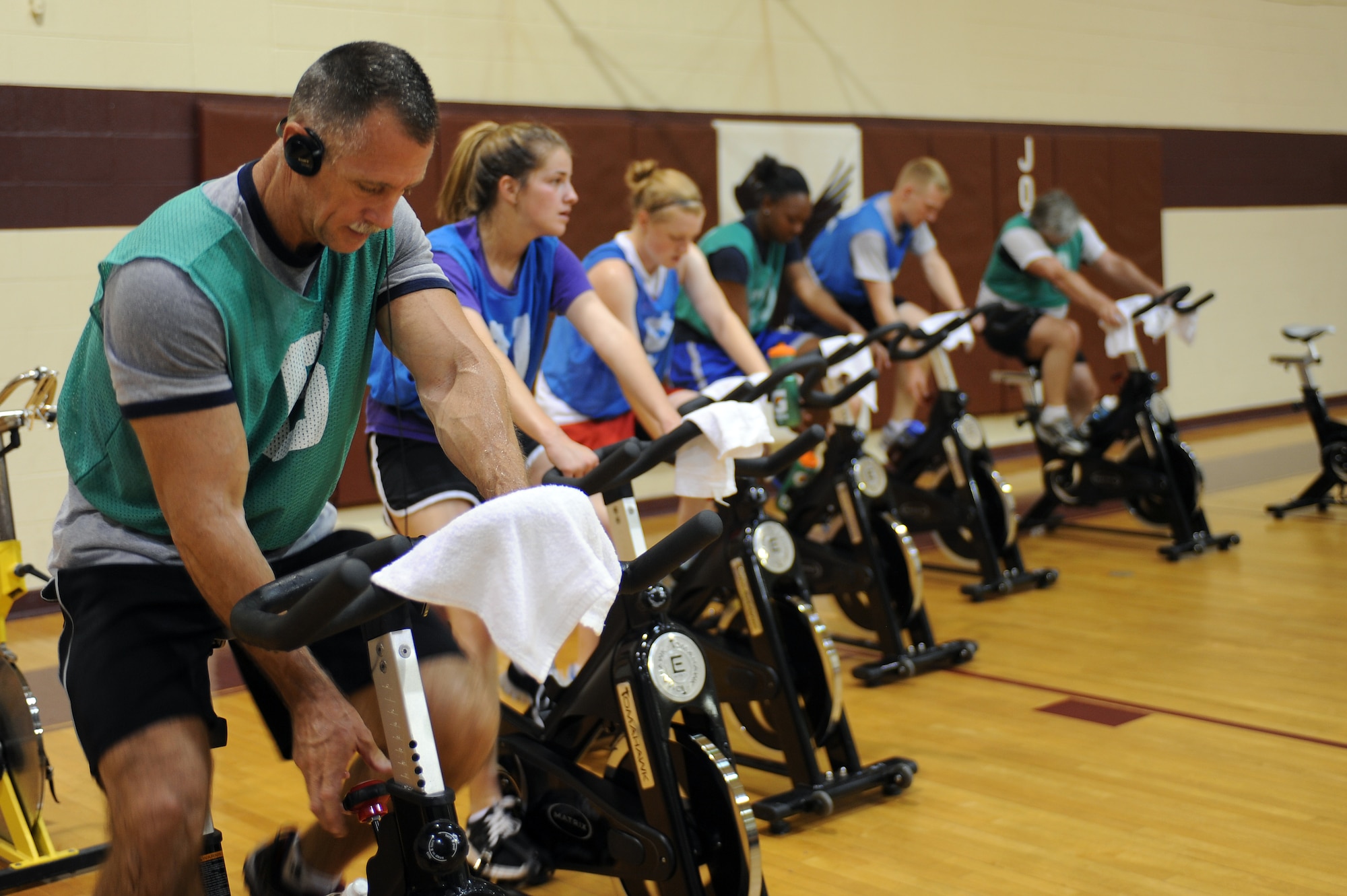 U.S. Air Force Senior Master Sgt. Timothy Moreland (left) increases resistance on a stationary bike during a boot camp challenge on Seymour Johnson Air Force Base, N.C., June 9, 2012. The event was held to test the physical limits of all who attended. Moreland, 916th Aerospace Medicine Squadron health services superintendent, is from Hollywood, Fla. (U.S. Air Force photo/Airman 1st Class John Nieves Camacho/Released)