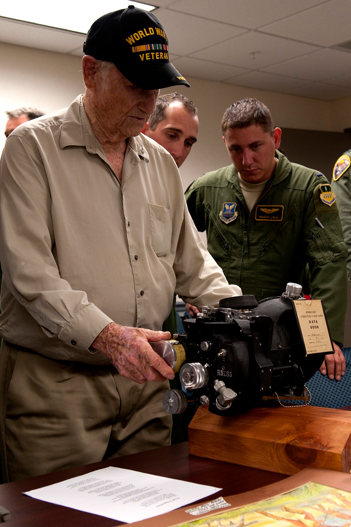 Claude McCrocklin shows airmen at the 11th Bomb Squadron how to work the Norden Bombsight, Barksdale Air Force Base, La., June 1, 2012. As a bombardier during World War II, McCrocklin took an oath to protect the secrets of the bombsight and to never let it fall into enemy hands. (U.S. Air Force photo by Master Sgt. Greg Steele/Released)