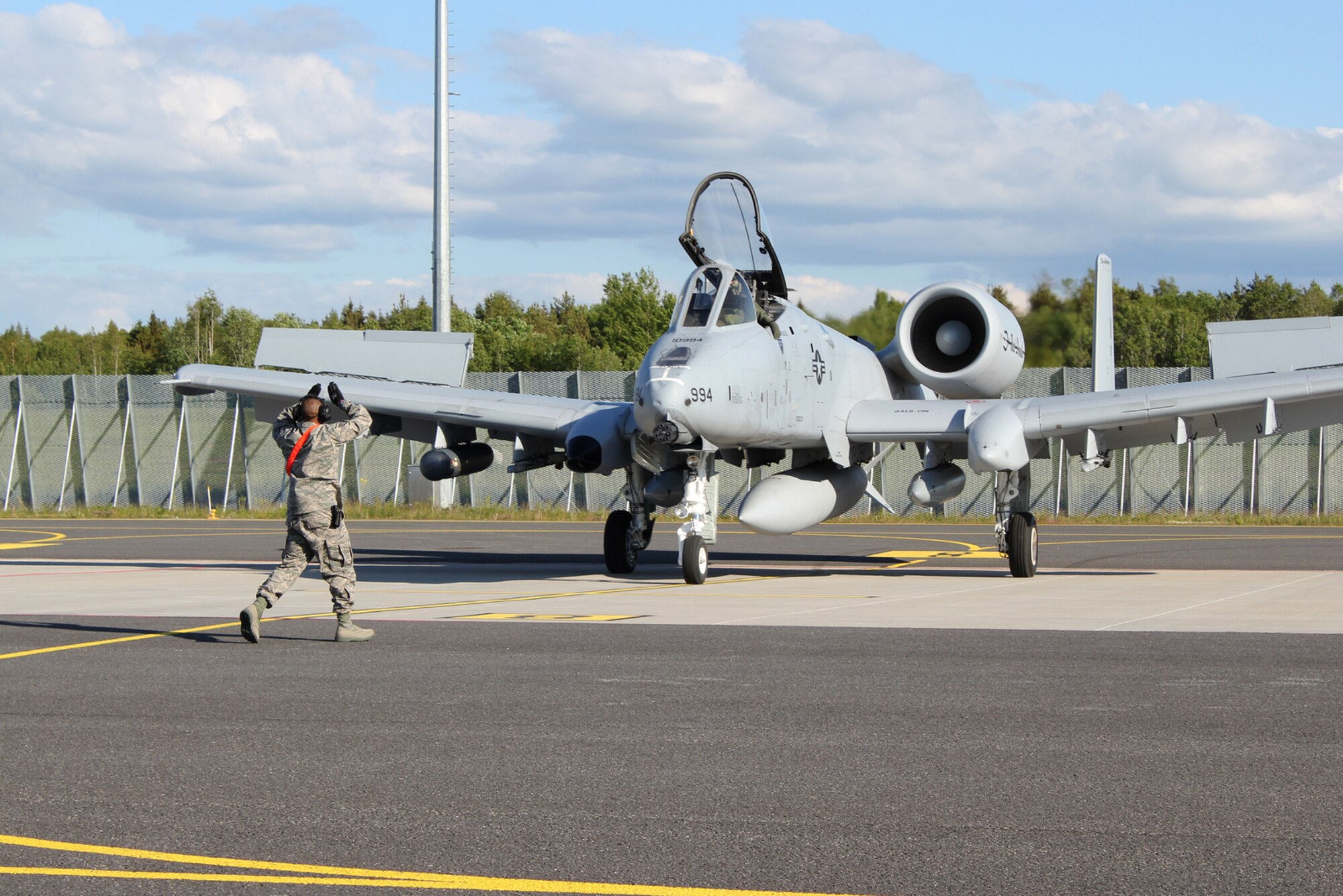 Staff Sgt. Cecil Manning, a crew chief with the 127th Maintenance Group, Michigan Air National Guard, guides an A-10 Thunderbolt II aircraft moments after it landed at Amari Air Base, Estonia, June 8, 2012. The aircraft, flown by the 107th Fighter Squadron, Michigan Air National Guard, are believed to be the first A-10s to ever land in Estonia. The aircraft and their Airmen were in Estonia to participate in Saber Strike 2012, a multi-national exercise based in Estonia and Latvia. (National Guard photo by Tech. Sgt. Dan Heaton)