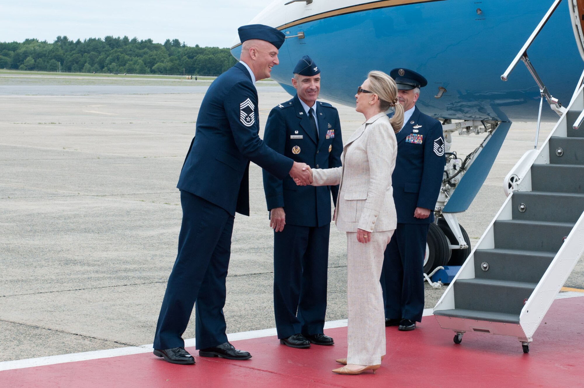 HANSCOM AIR FORCE BASE, Mass. – Secretary of State Hillary Clinton greets Chief Master Sgt. Baird Stiefel (left), 66th Air Base Group superintendent, and Col. Lester A. Weilacher, 66th Air Base Group commander, upon her arrival to the base June 11. The secretary flew to Hanscom en route to speak at the opening of the Inaugural Women in Public Service Institute at Wellesley College. (U.S. Air Force photo by Rick Berry)