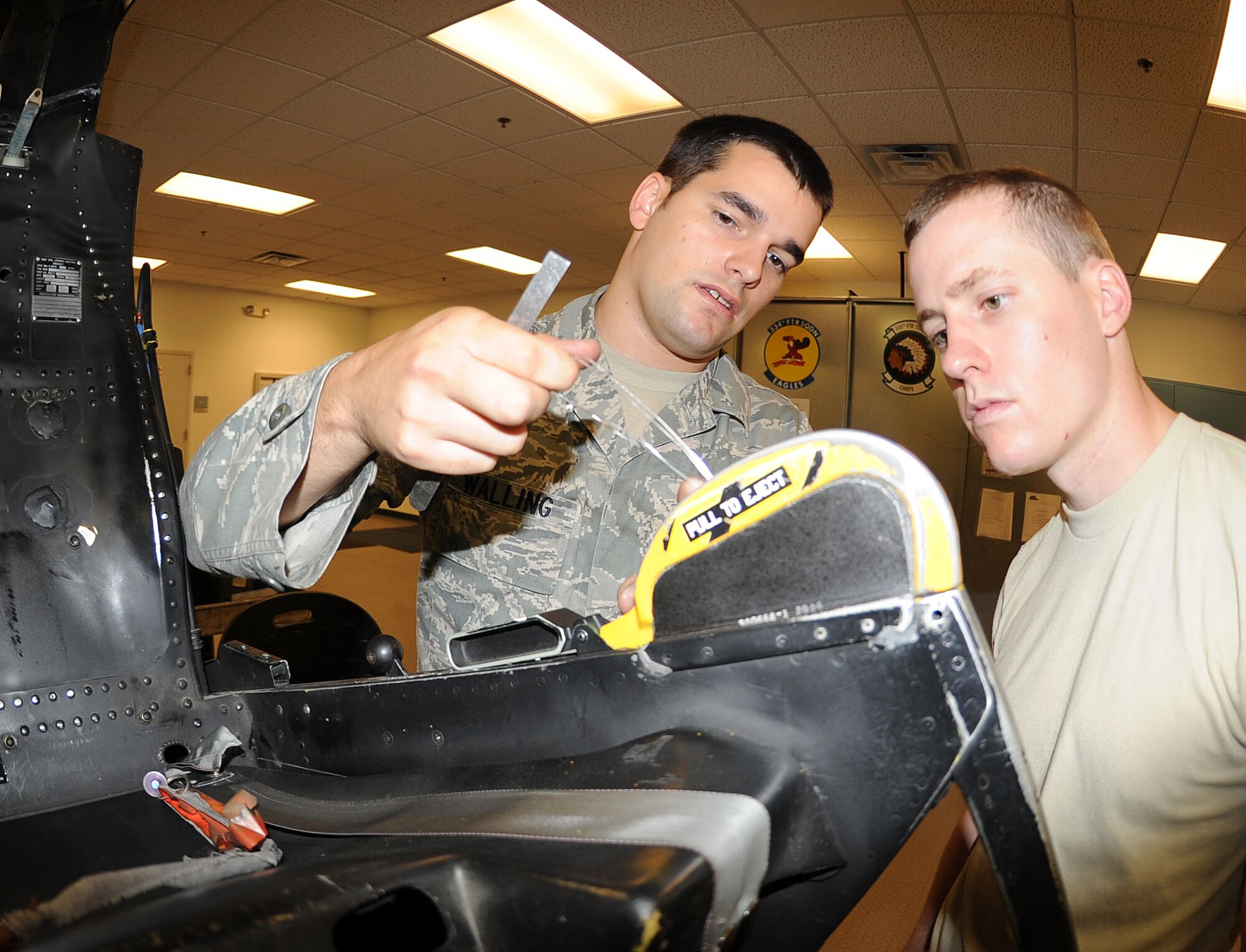 U.S. Air Force Senior Airman John Walling and Airman 1st Class Jacob Anderson conduct a firing control handle pull check on Seymour Johnson Air Force Base, N.C., June 12, 2012. The control handle allows aircrew to eject from their aircraft in case of an emergency. Walling, 4th Component Maintenance Squadron egress journeyman, hails from Tulsa, Okla. Anderson, 4th CMS egress apprentice, hails from Reno, Nev. (U.S. Air Force photo/Senior Airman Gino Reyes/Released)