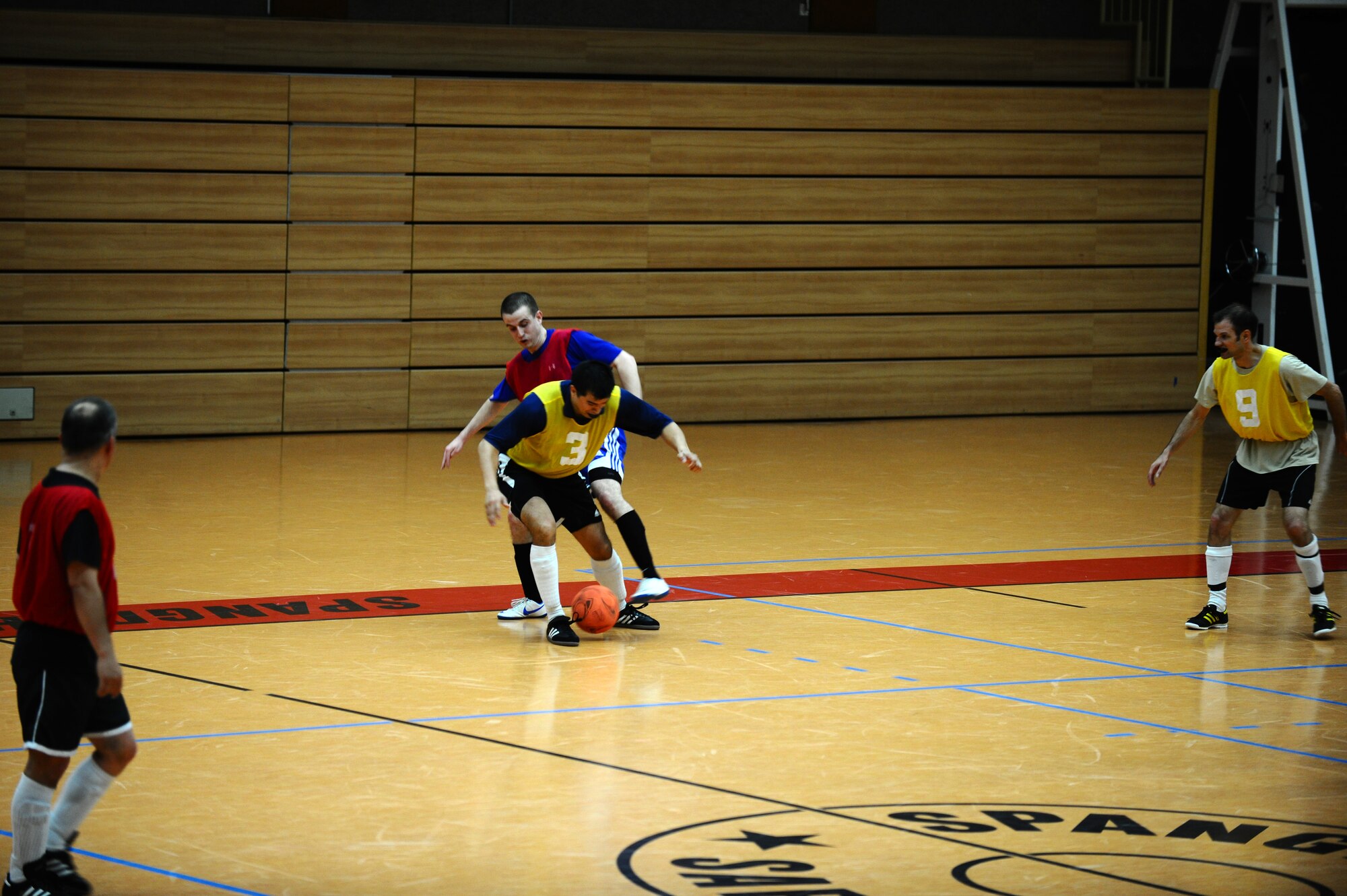 SPANGDAHLEM AIR BASE, Germany – Rodney Curtis, yellow, 81st Fighter Squadron, and Carl Miller, red, 52nd Force Support Squadron, struggle for control of the soccer ball during the indoor soccer championship at the Skelton Memorial Fitness Center here June 12. The 52nd FSS defeated the 81st FS in the first game 7-6. The 81st FS won the double-elimination championship after winning the second game 9-5. (U.S. Air Force photo by Airman 1st Class Matthew B. Fredericks/Released)