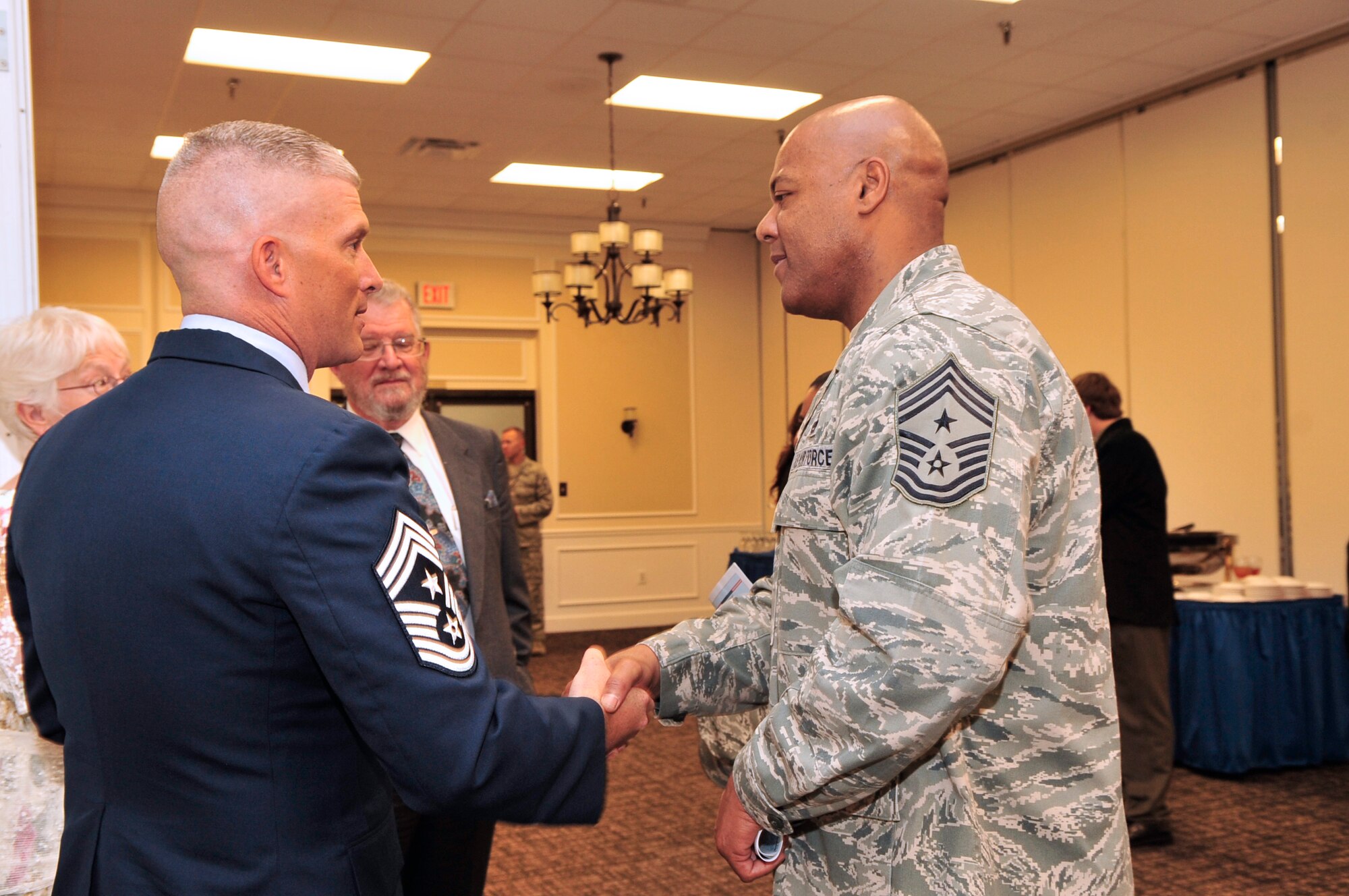 U.S. Air Force Chief Master Sgt. James Wilkerson, 20th Fighter Wing command chief, congratulates Chief Master. Sgt. Robert Brooks, 9th Air Force command chief, at his retirement ceremony at Shaw Air Force Base, S.C., June 8, 2012. Brooks has been in the Air Force since 1987.(U.S. Air Force photo by Airman Nicole Sikorski/Released)