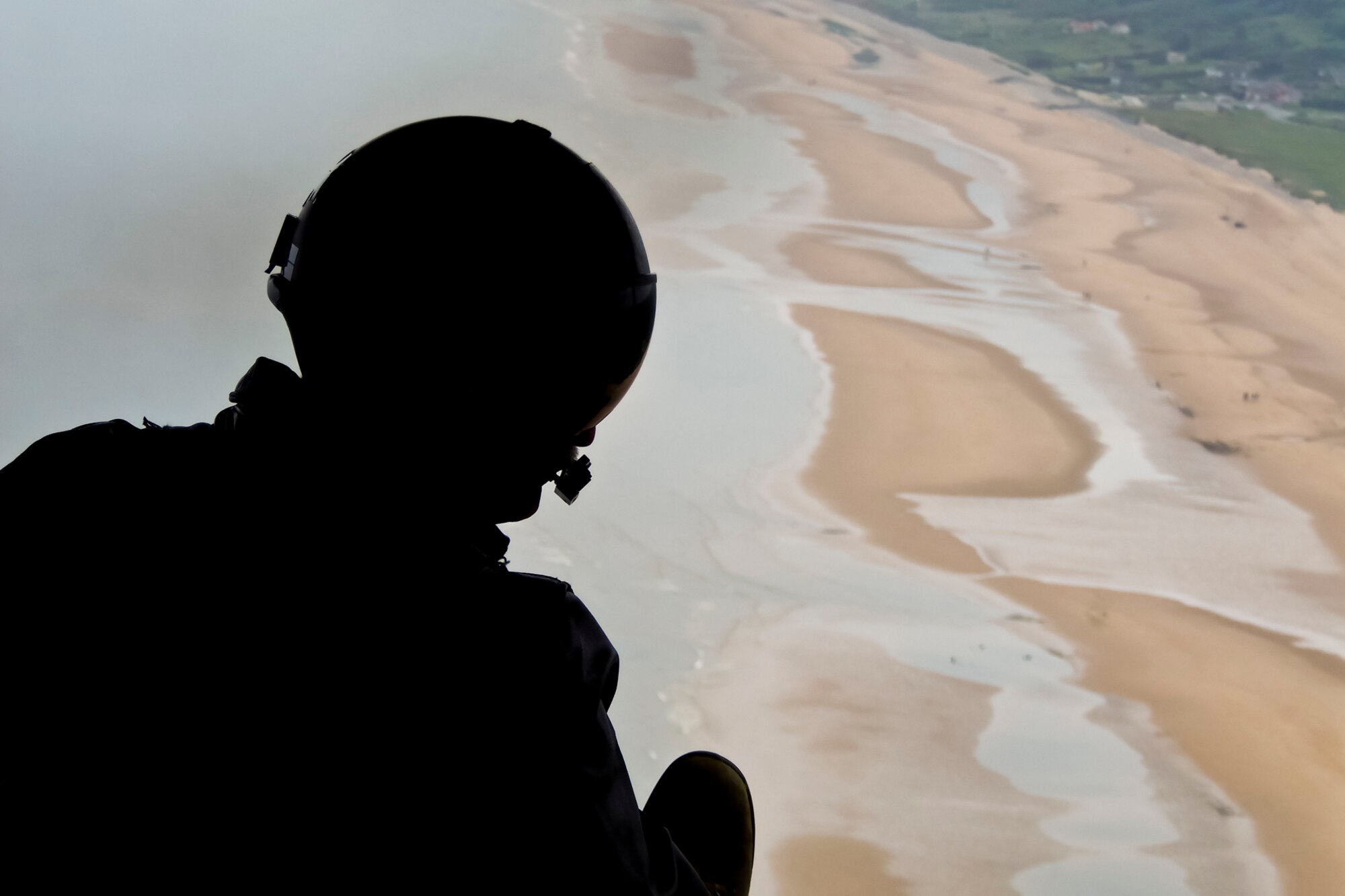NORMANDY, France -- A 910th Airlift Wing loadmaster based at Youngstown Air Reserve Station (YARS), Ohio, gazes at the beach here, June 1, 2012 from the open cargo area of a YARS C-130H aircraft. 910th AW Airmen attended the annual re-enactment of D-Day here. U.S. Air Force photo by Tech. Sgt. Ben Sewall
