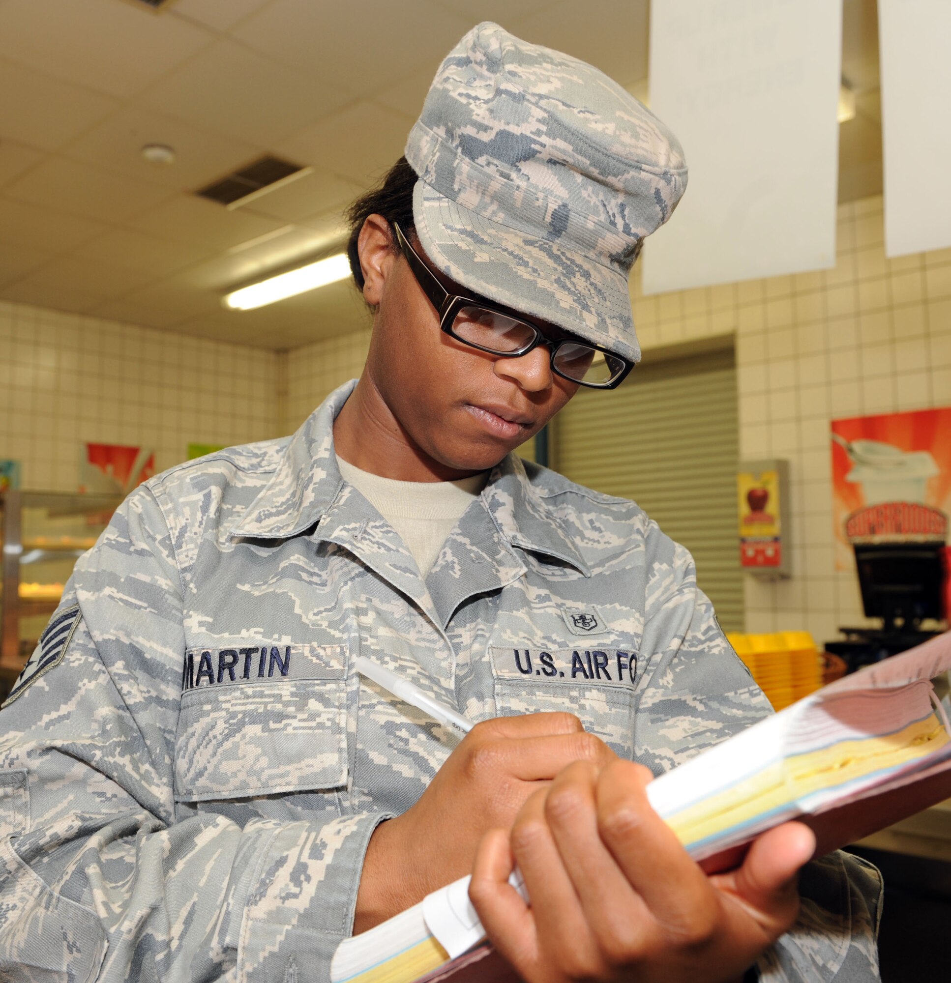 SPANGDAHLEM AIR BASE, Germany – Staff Sgt. Ashley Martin, 52nd Aerospace Medicine Squadron public health technician, takes notes during a food and facility inspection at the Spangdahlem Middle School cafeteria here June 12. The 52nd AMDS Food Safety and Sanitation Office conducts monthly inspections for the middle school and all other food facilities on base to ensure those facilities meet or exceed health standards. These standards allow the facilities to serve quality food to the customers. (U.S. Air Force photo by Senior Airman Christopher Toon/Released)