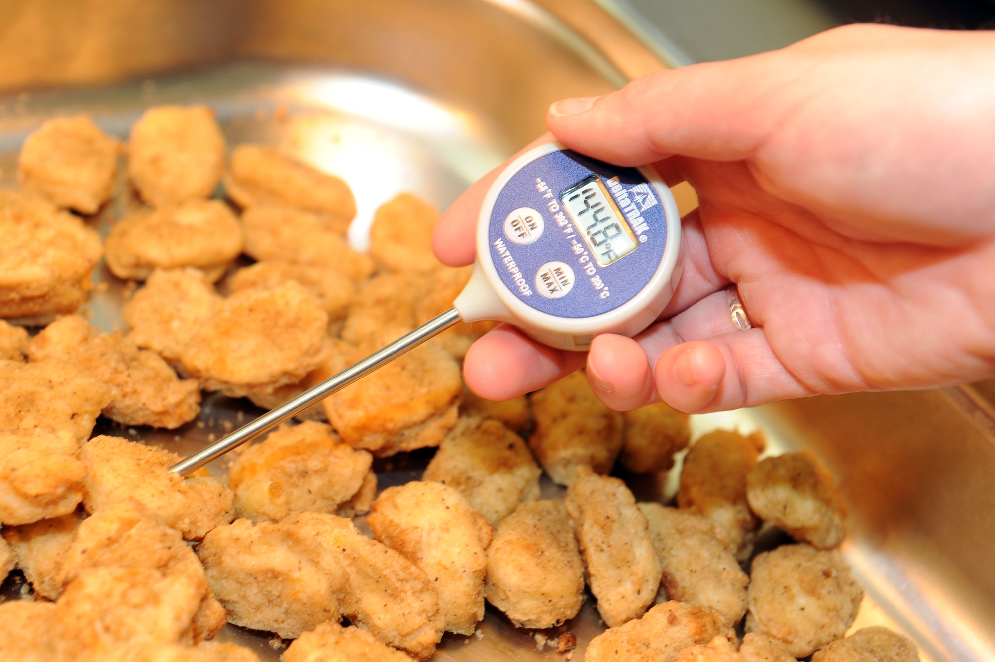 SPANGDAHLEM AIR BASE, Germany – Airman 1st Class Sierra Halstead, 52nd Aerospace Medicine Squadron public health technician, uses a digital thermometer to check the internal temperature of a chicken nugget during a food and facility inspection at the Spangdahlem Middle School cafeteria here June 12. The 52nd AMDS Food Safety and Sanitation Office conducts monthly inspections for the middle school and all other food facilities on base to ensure those facilities meet or exceed health standards. These standards allow the facilities to serve quality food to the customers. (U.S. Air Force photo by Senior Airman Christopher Toon/Released)