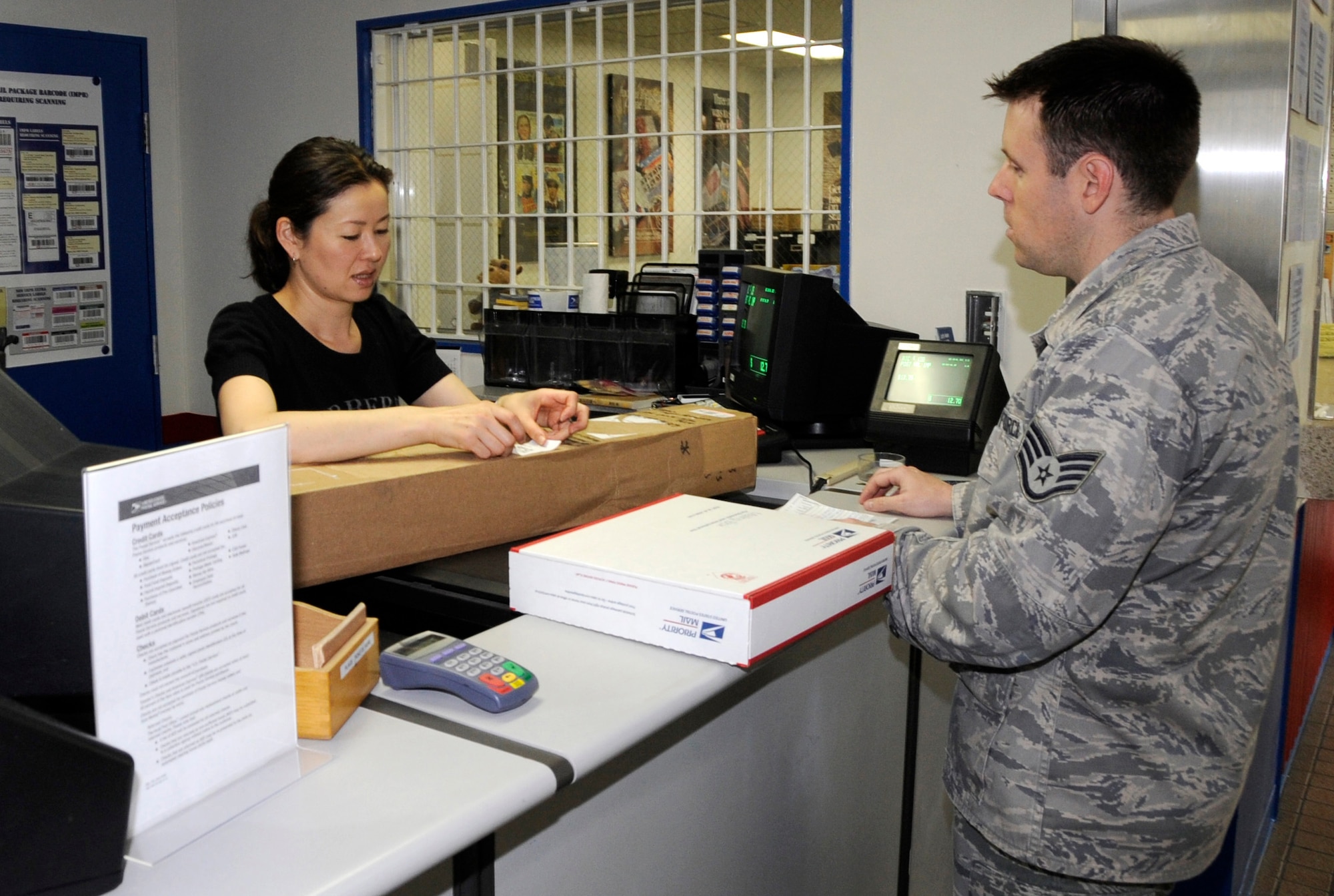 Saori Ohmuro, Misawa Air Base Post Office postal clerk, processes a package for U.S. Air Force Staff Sgt. Matthew Pontones, 301st Intelligence Surveillance Reconnaissance Group unit deployment manager, at Misawa Air Base, Japan, June 6, 2012. Ohmuro ensures parcels are marked properly before distribution. For more information about the base post office call 226-3492. (U.S. Air Force photo by Airman 1st Class Kaleb Snay/Released)