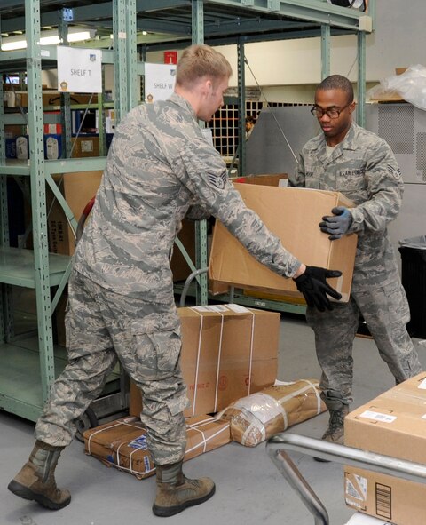 U.S. Air Force Staff Sgt. Chris Steinberg(left) assists Senior Airman Brandon Moore, 35th Communications Squadron postal clerks, with processing parcels from the first truck of the day at Misawa Air Base, Japan, June 6, 2012. The base post office gets three trucks every duty day carrying about 4,000 packages in each truck. For more information about the base post office call 226-3492. (U.S. Air Force photo by Airman 1st Class Kaleb Snay/Released)