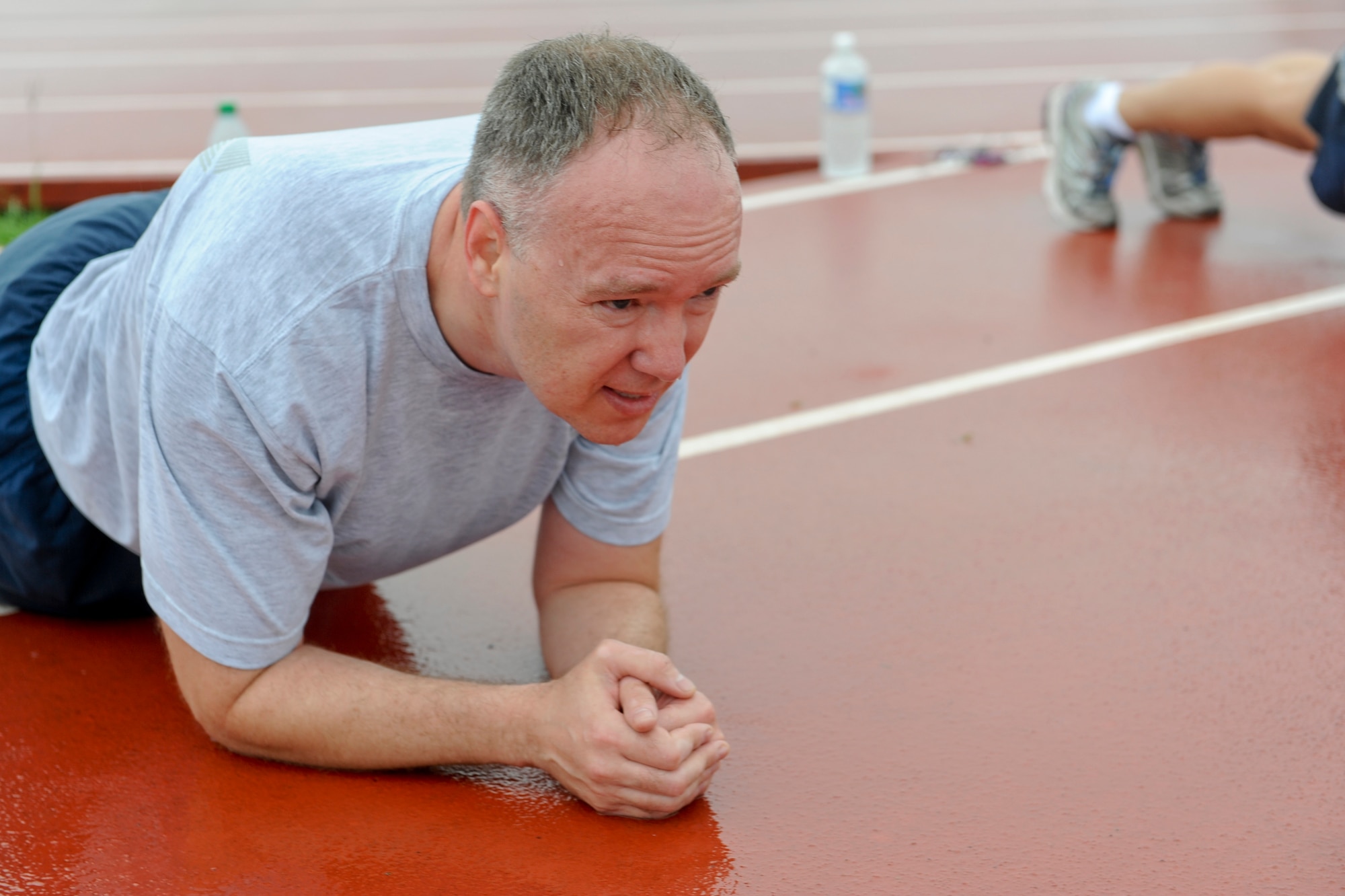 U.S. Air Force Major Christopher Anderson, 18th Wing Public Affairs chief, performs a plank exercise during a physical training session at the Risner Fitness Center track on Kadena Air Base, Japan, June 13, 2012. Knowing the flag conditions, monitoring water intake and work/rest cycles can help prevent injuries while conducting physical fitness activities or work outside this summer.  (U.S. Air Force photo/Airman 1st Class Justin Veazie)
