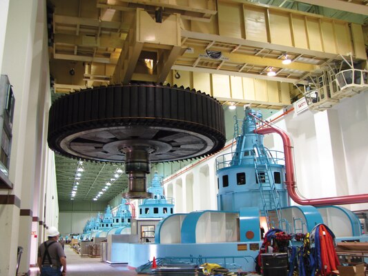 A contract worker watches as a crane moves a 1,200-ton rotor as part of McNary Lock and Dam's stator winding replacement near Umatilla, Ore. in August 2010.