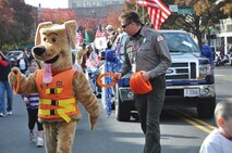 Bobber, the Corps' water safety dog and District Natural Resource Resource Speicalist Michael Swenson hand out frisbees during the Veteran's Day Parade on Main Street in Walla Walla, Wash. on Veteran's Day 2011.