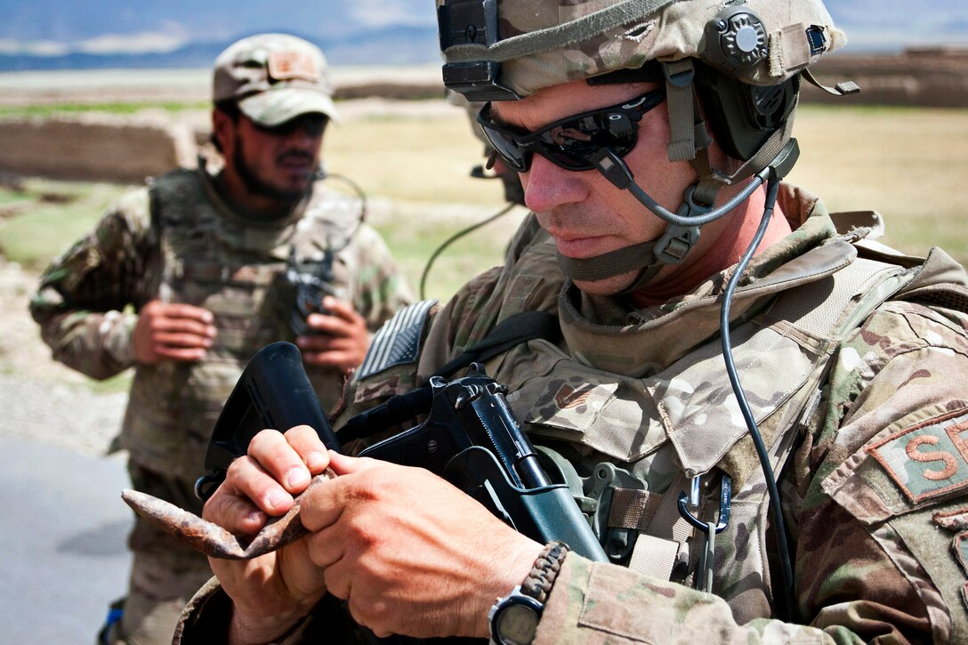 U.S. Air Force Tech Sgt. Dale Spencer inspects an old round of ammunition found by his airmen near a cave on a mountainside near Bagram Air Base in Afghanistan's Parwan province, June 6, 2012. Spencer is assigned to the 455th Air Expeditionary Wing.