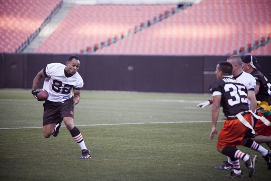 Staff Sgt. Lopaz Swain, a member of the Marine Corps, runs with the ball during the Marine versus Cleveland First Responders game at the Cleveland Browns Stadium as part of Marine Week Cleveland June 13, 2012. A large crowd came out to support the friendly match-up, which is one of many events offered during Marine Week Cleveland. At half time, the Quantico Marine Corps Band performed several numbers and Marines re-enacted the flag raising on Iwo Jima. The first responders came out on top at the end of the game, beating the Marine Corps team 28-0. More than 750 Marines will be in Cleveland until June 17 displaying Marine aircraft, vehicles and equipment, as well as interacting and sharing with the public the values and character of the Marine Corps. One of the culminating events will be a Marine Air Ground Task Force demonstration, which showcases Marines' ability to assault from ship-to-shore via ground and air, June 16-17 at Burke Lakefront Airport.::r::::n::