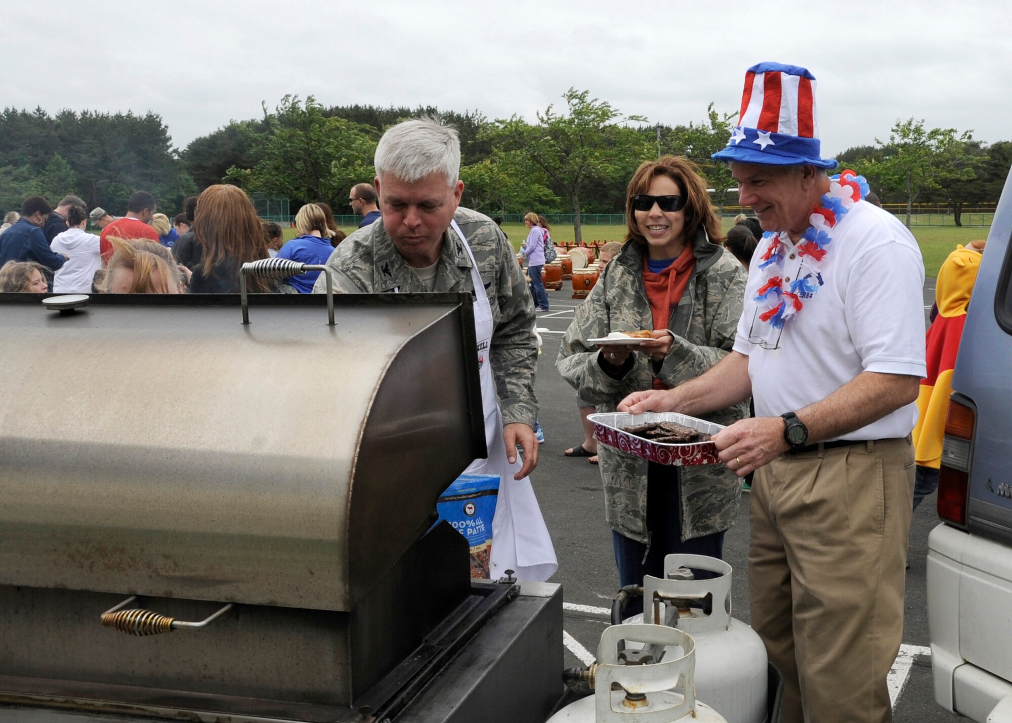 U.S. Air Force Col. Al Wimmer (left), 35th Fighter Wing vice commander, grills hamburger patties during a farewell luncheon for Scott Sterry, Cummings Elementary School principal, at Misawa Air Base, Japan, June 14, 2012. After spending 25 years working overseas, Sterry has decided to step down as principal of Cummings and return back to the states to spend time with his family. (U.S. Air Force photo by Airman 1st Class Kaleb Snay/Released)