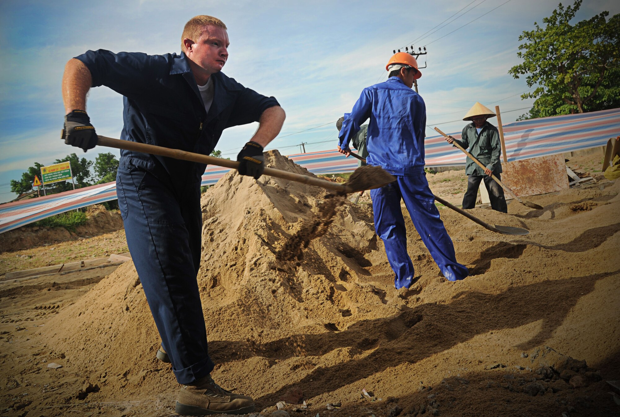 Tech. Sgt. Greg Brown, a plumber with the 647th Civil Engineering Squadron at Joint Base Pearl Harbor-Hickam, Hawaii, shovels sand to level the grounds of the Xuan Lam Medical Clinic in Nghe An Province, Vietnam, June 12. Brown is participating in Operation Pacific Angel-Vietnam 12, an eight-day humanitarian assistance operation. The PACANGEL CE team has been working to restore the clinic alongside members of the Vietnamese military, local contractors, and residents of a nearby village. Operation Pacific Angel gives the U.S. an opportunity to support the efforts of partner nations in the Pacific region by providing medical, dental, optometry and engineering assistance to the host nation citizens. (U.S. Air Force photo/Senior Airman Lauren Main) 
