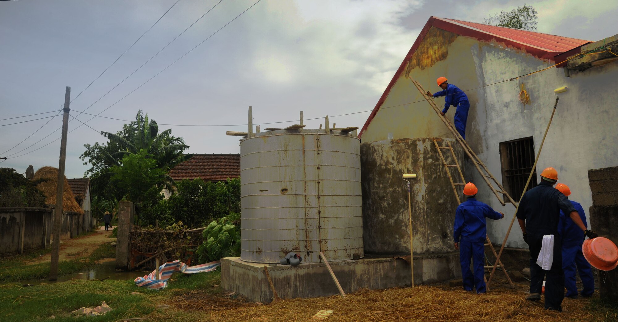 A U.S. Airman (right) participates in Pacific Angel-Vietnam in Nghe An Province, Vietnam, while restoring the Xuan Lam Medical Clinic alongside, Vietnam People's Armed Forces members, June 10. Officially in its fifth year,  PACANGEL is a joint and combined humanitarian assistance mission led by 13th Air Force. Operation Pacific Angel gives the U.S. an opportunity to support the efforts of partner nations in the Pacific region by providing medical, dental, optometry and engineering assistance to the host nation citizens. (U.S. Air Force photo/Senior Airman Lauren Main) 
