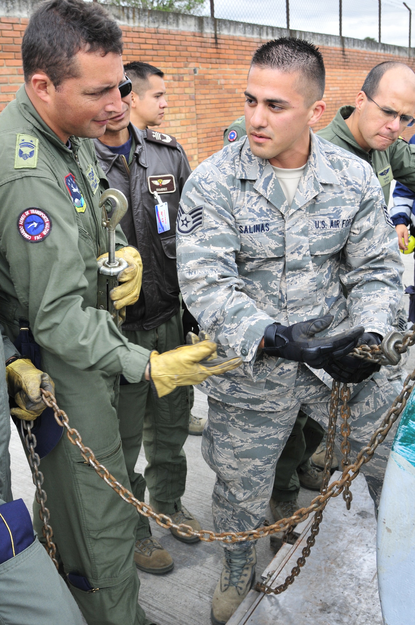 Staff Sgt. Peter Salinas, 571st Mobility Support Advisory Squadron air transportation air advisor, explains to Técnico Subjefe Hector Sierra, Colombian air force, how to properly connect chains to build a chain bridle during the final day of the equipment preparation seminar June 8 at Commando Aéreo de Transporte Militar, Bogota, Colombia.  Chains are used on heavy single items, whereas nets are used for bulk cargo.  (U.S. Air Force photo by Tech. Sgt. Lesley Waters)