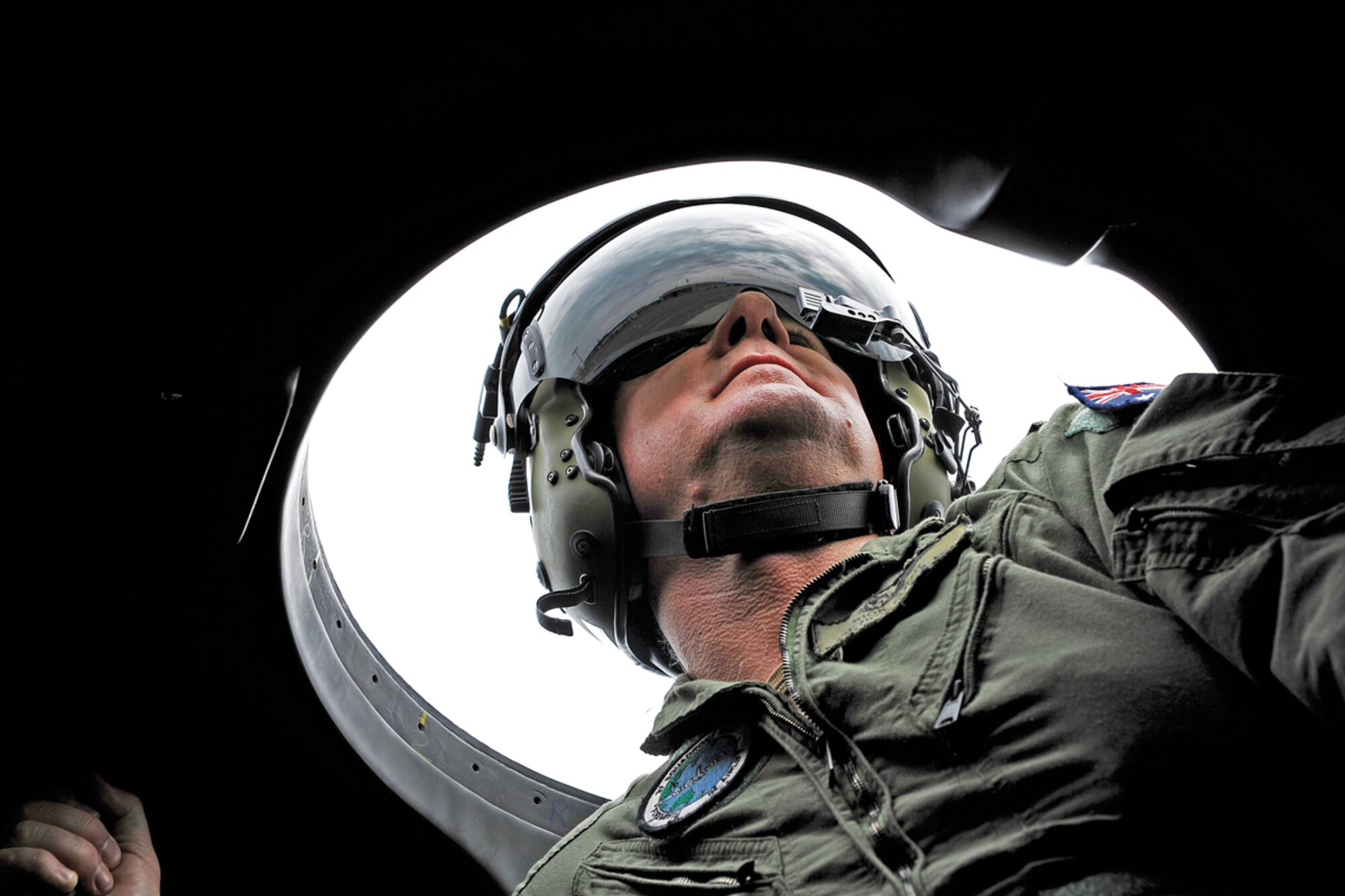 JOINT BASE ELMENDORF-RICHARDSON, Alaska -- Royal Australian Air Force Warrant Officer Rick Smith looks through the sky bubble of a RAAF C-130H Hercules Monday. The sky bubble is used to check for aircraft in blind spots of the plane. (U.S. Air Force photos/Airman 1st Class Omari Bernard)