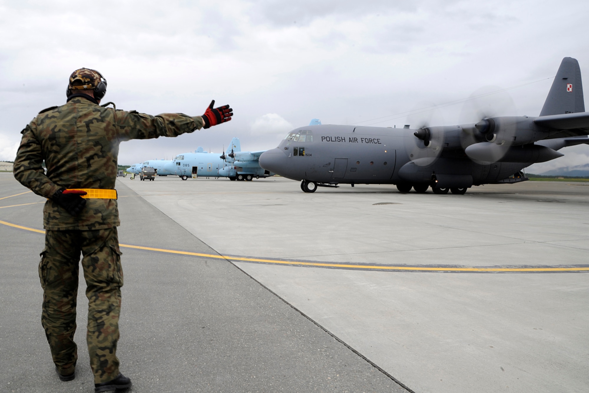 A member of the Polish Air Force C-130 Hercules crew guides the aircraft to begin to taxi to the runway during Red Flag-Alaska on Joint Base Elmendorf-Richardson June 13, 2012. The goal of Red Flag-Alaska is to provide each aircrew with vital first missions to increase their chances of survival in combat environments. (U.S. Air Force photo/Staff Sgt. Zachary Wolf)