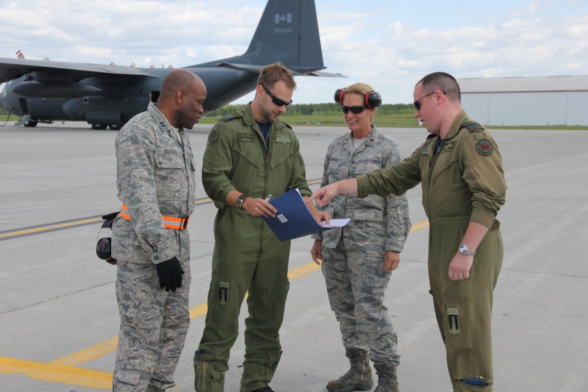 Capt. Napoleon Solages (l) and Maj. Shirley Whitney meet with Royal Canadian Air Force C-130 Hercules crew members at Cold Lake Air Base in Alberta, Canada, during the Maple Flag international military exercise. The installation is offically called 4 Wing Cold Lake and home to fighter training for Canadian forces. (Courtesy photo)