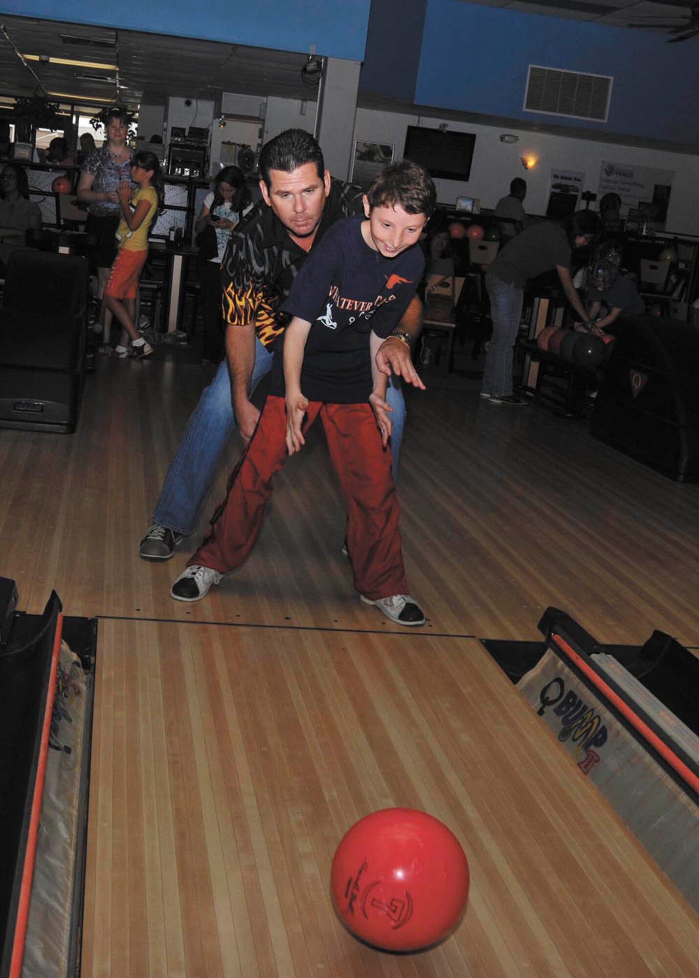 Lloyd Harris helps son, Richard, 12, bowl during the special needs bowling event sponsored by Joint Base San Antonio-Lackland First Sergeants Council Saturday at the Skylark Bowling Center. (U.S. Air Force photo/Alan Boedeker)
