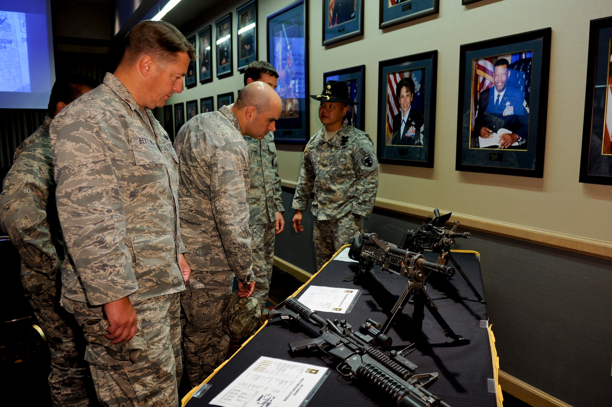 VANDENBERG AIR FORCE BASE, Calif.-- Team V members look over weapons used by the U.S. Army during the 237th Army Birthday Celebration at the Pacific Coast Club here Thursday, June 14, 2012. Founded in 1775, the U.S. Army has grown from an amateur force of colonial freedom fighters to a professional force of more than one million soldiers fighting terrorism worldwide and providing support for international operations. (U.S. Air Force photo/Staff Sgt. Levi Riendeau)