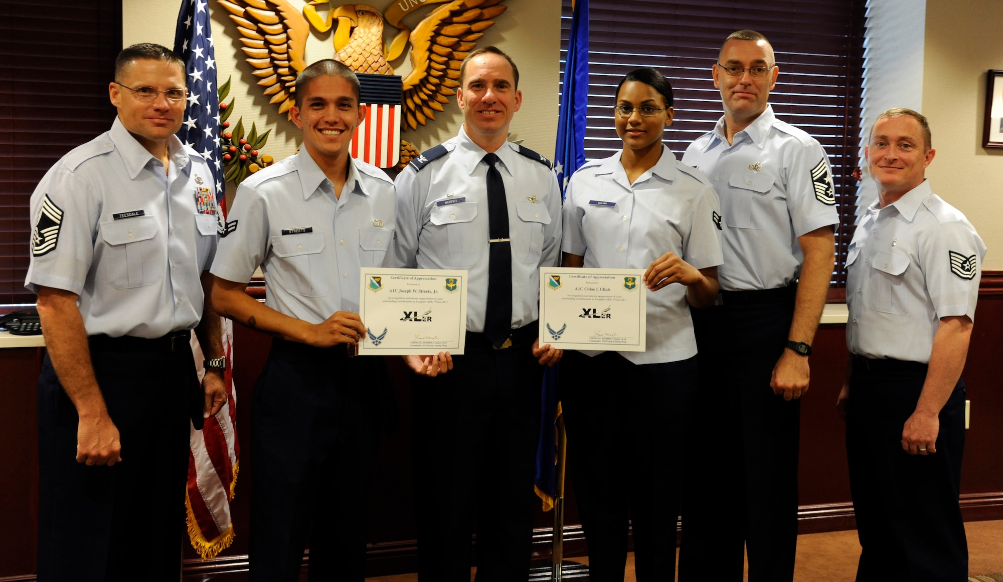 Airman 1st Class Joe Streets, 47th Operations Support Squadron air traffic control journeyman, and Airman 1st Class Chloe Ullah, 47th Medical Operations Squadron public health technician, pose with Col. Tom Murphy, 47th Flying Training Wing commander, and Chief Master Sgt. Garry Berry, 47th FTW command chief, after being presented the XLer of the week award at Laughlin Air Force Base, Texas, June 11, 2012. The XLer is a weekly award chosen by wing leadership and given to those who consistently make outstanding contributions to Laughlin and their unit. (U.S. Air Force photo/Airman 1st Class Nathan Maysonet)