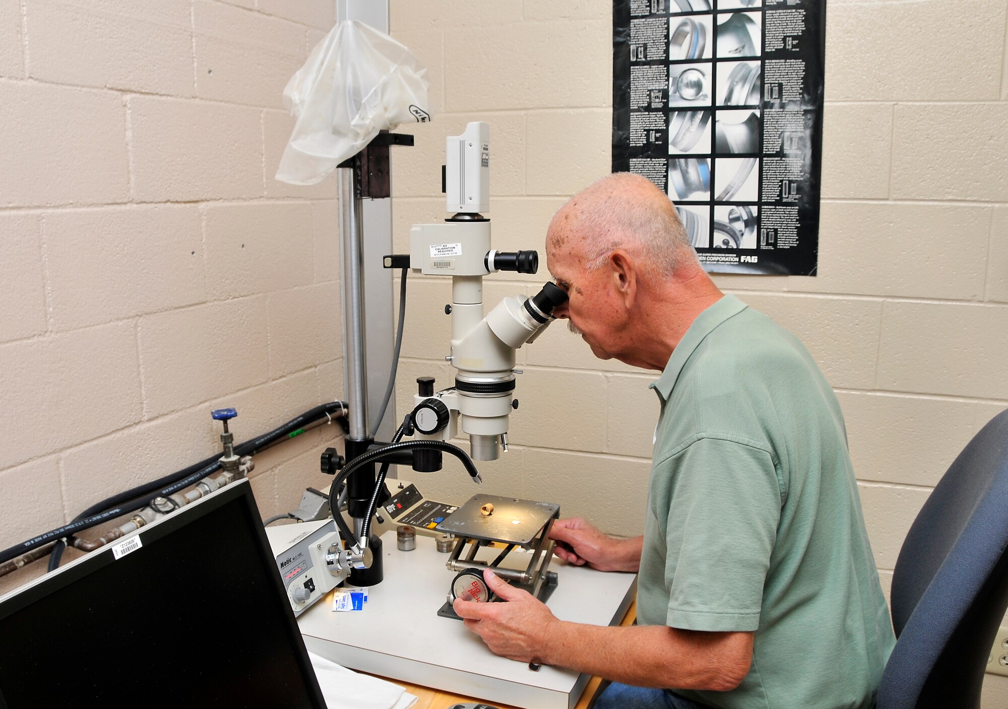 ATA Labs Section Manager Steve Ary uses a microscope to examine a threaded pipe bushing with a piece of broken tubing inside it in AEDC’s Met Lab. (Photo by Rick Goodfriend)