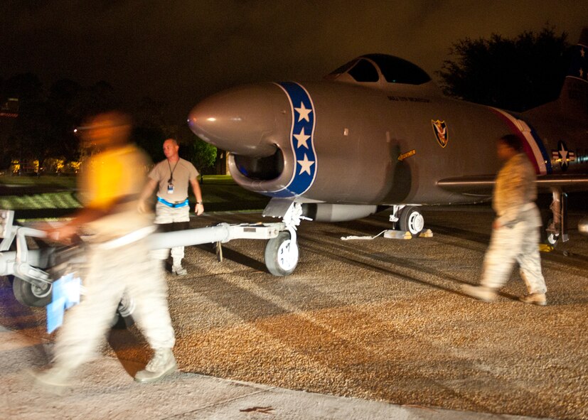 Moody Airmen work quickly to position a newly refurbished F-86L Sabre onto its display at the President George W. Bush Air Park at Moody Field in the early morning of June 12, 2012, at Moody Air Force Base, Ga. The historic aircraft arrived on a flat-bed truck April 25 from downtown Valdosta where it was known as a famous landmark that commemorated the late U.S. Air Force Maj. Lyn McIntosh and the heritage of the Flying Tigers. A re-dedication ceremony will be held with the McIntosh family present, forever placing the aircraft with other pieces of history at the air park. McIntosh, a Valdosta native, was one of five Airmen who died April 25, 1980, during Operation Eagle Claw, a mission ordered by President Jimmy Carter to rescue 52 Americans held captive in Iran. (U.S. Air Force photo by Senior Airman Eileen Meier/Released)