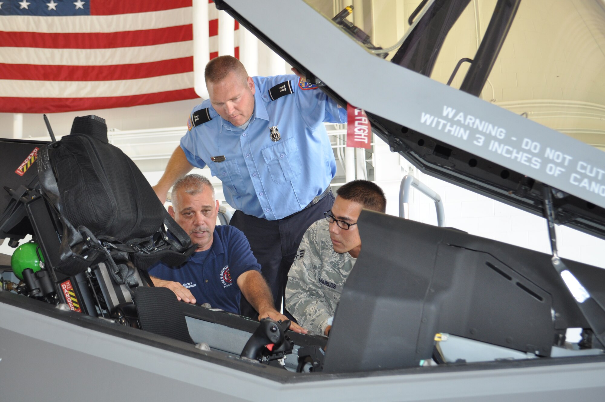 Eglin lead firefighter, Brian Johnson explains to Tyndall's lead firefighter John Christopherson and Senior Airman Jacob Banuelos details to shutting down a F-35A Joint Strike Fighter during training.  Tyndall AFB is an alternate landing site for the airplanes. (USAF photo/Maj. Karen Roganov)