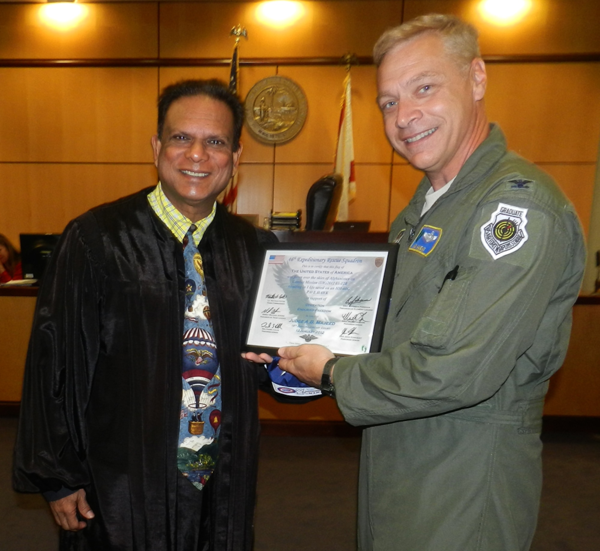 Just in time for Flag Day, June 13, Col. Robert Ament (left to right), 920th Rescue Wing vice commander, Patrick Air Force Base, Fla., presented a flag to the Honorable Alli Baksh Majeed, judge, 18th Judicial Circuit, Melbourne, Fla., in his courtroom. Injured Marine veteran, Mr. Sonny Hartwell and Mr. Kenneth Dunivant assisted in folding the flag. The flag was flown in honor of Judge Majeed aboard a rescue mission performed six months earlier in Afghanistan by Rescue Wing Airmen. (U.S. Air Force photo/Capt. Cathleen Snow)