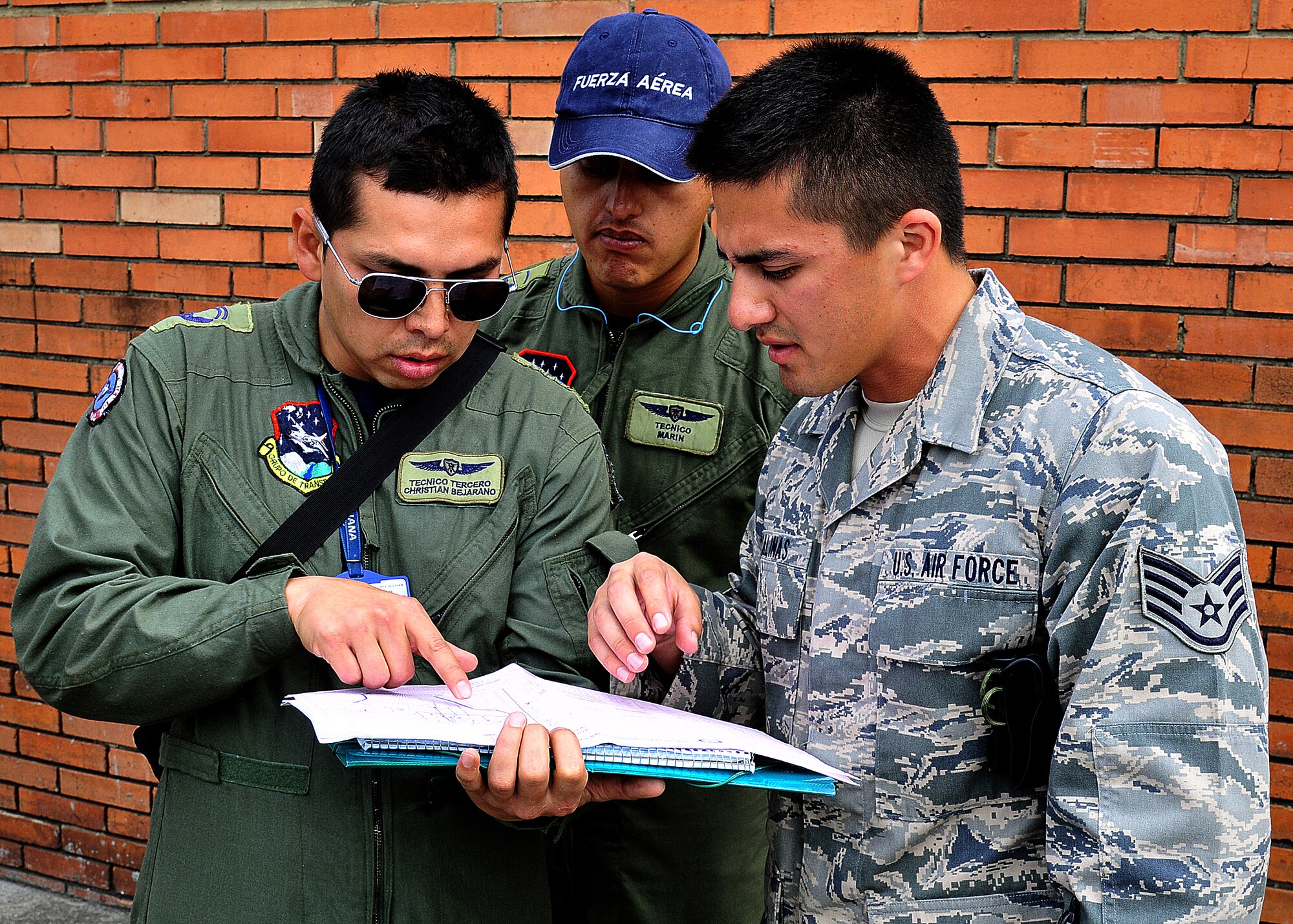 Técnico Cuarto Ronald Marin, Colombian air force, looks on as Técnico Tercero Christian Bejarano, Colombian air force, and Staff Sgt. Peter Salinas, 571st Mobility Support Advisory Squadron air transportation air advisor, discuss how the Colombian air force does their load plans for their different air frames during the hands on pallet build-up seminar June 6 at Commando Aéreo de Transporte Militar, Bogota, Colombia.    (U.S. Air Force photo by Tech. Sgt. Lesley Waters)