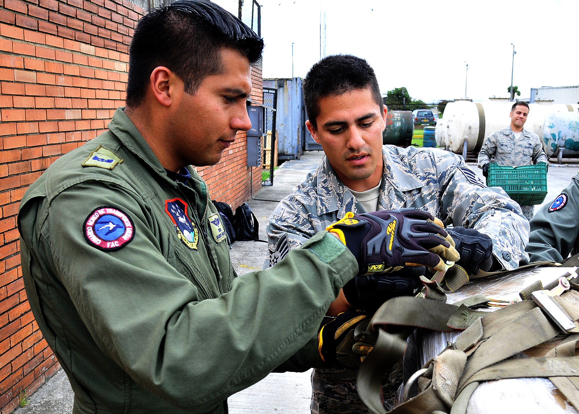 Staff Sgt. Peter Salinas, 571st Mobility Support Advisory Squadron air transportation air advisor, works with Técnico Edwin Camacho, Colombian air force, secure cargo straps during the hands on pallet build-up seminar June 6 at Commando Aéreo de Transporte Militar, Bogota, Colombia.  (U.S. Air Force photo by Tech. Sgt. Lesley Waters)