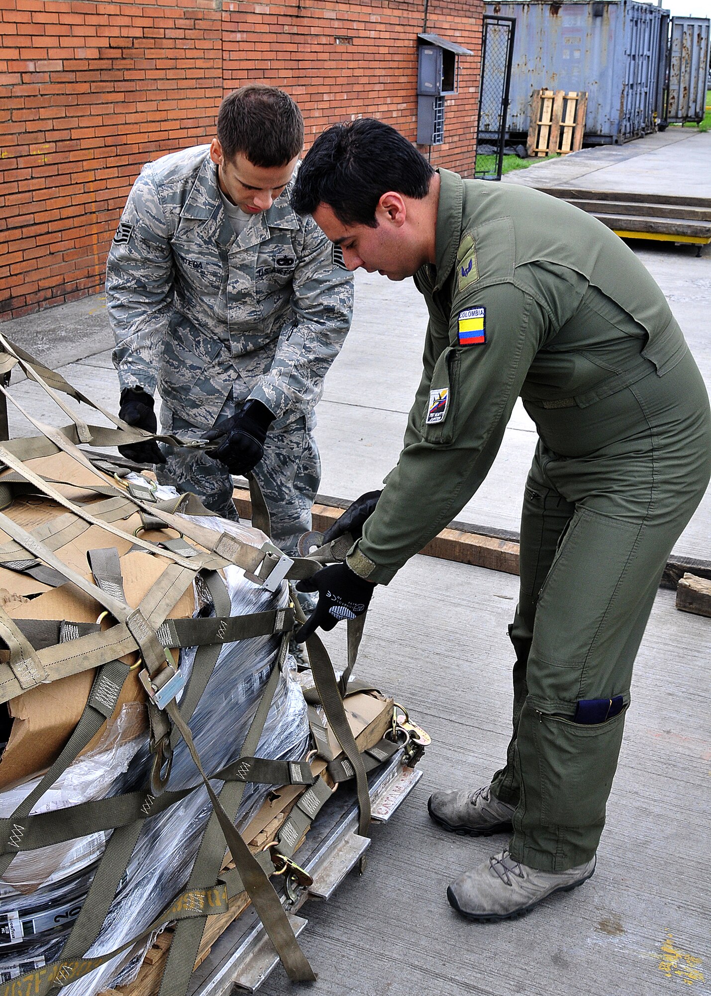 Staff Sgt. Angel Ortega, 571st Mobility Support Advisory Squadron air transportation air advisor, works with Técnico Cuarto Cesar Gomez, Colombian air force, on properly securing cargo during the pallet build-up seminar June 6 at Commando Aéreo de Transporte Militar, Bogota, Colombia.  (U.S. Air Force photo by Tech. Sgt. Lesley Waters)