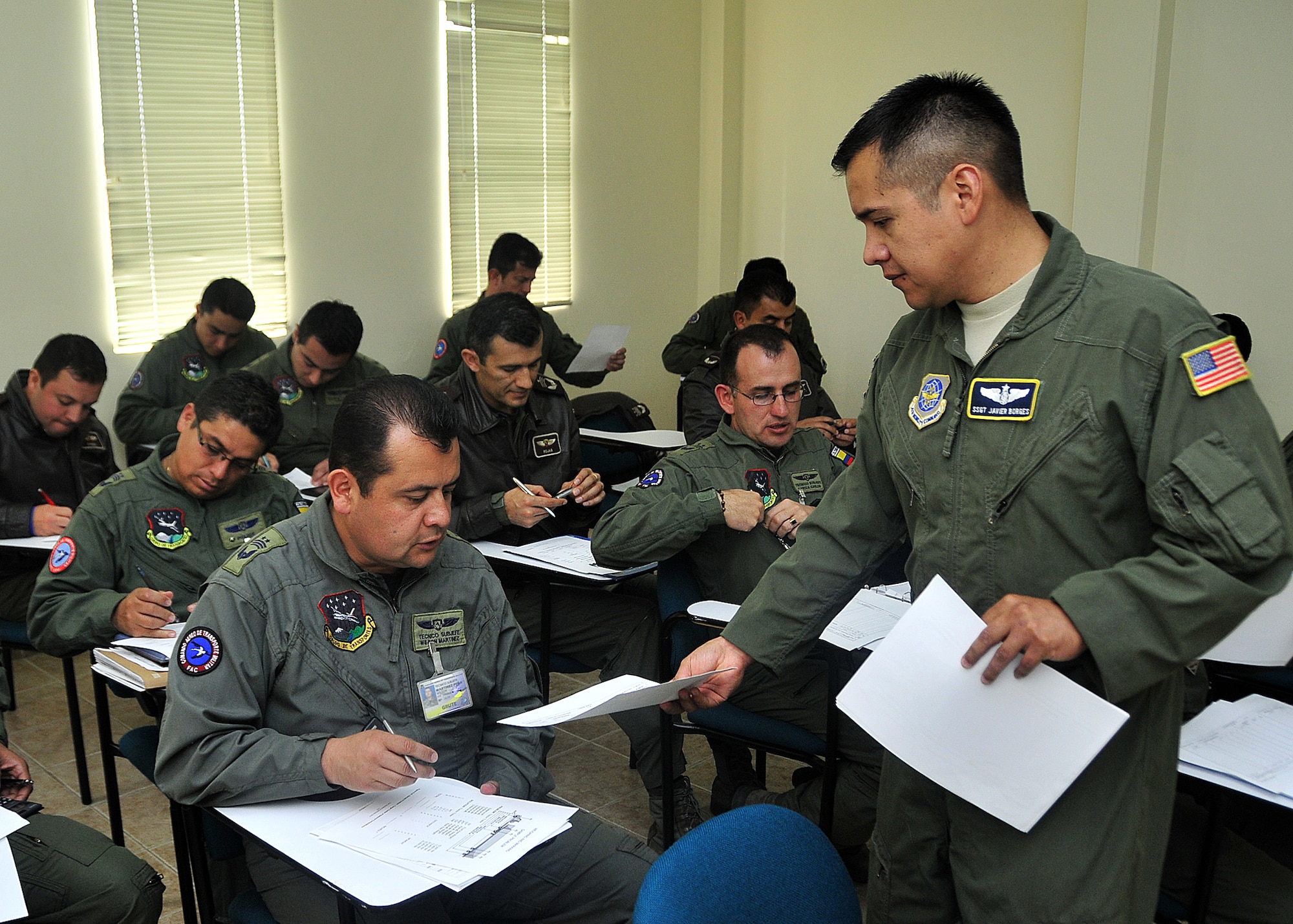 Staff Sgt. Javier Borges, 571st Mobility Support Advisory Squadron loadmaster air advisor, provides practical exercise to calculate center of balance for rolling stock handouts to Técnico Subjefe Wilson Martinez, Colombian air force, during the second day of seminars June 6 at Commando Aéreo de Transporte Militar, Bogota, Colombia.  Rolling stock is vehicles, trailers or generators loaded onto aircraft.  (U.S. Air Force photo by Tech. Sgt. Lesley Waters)