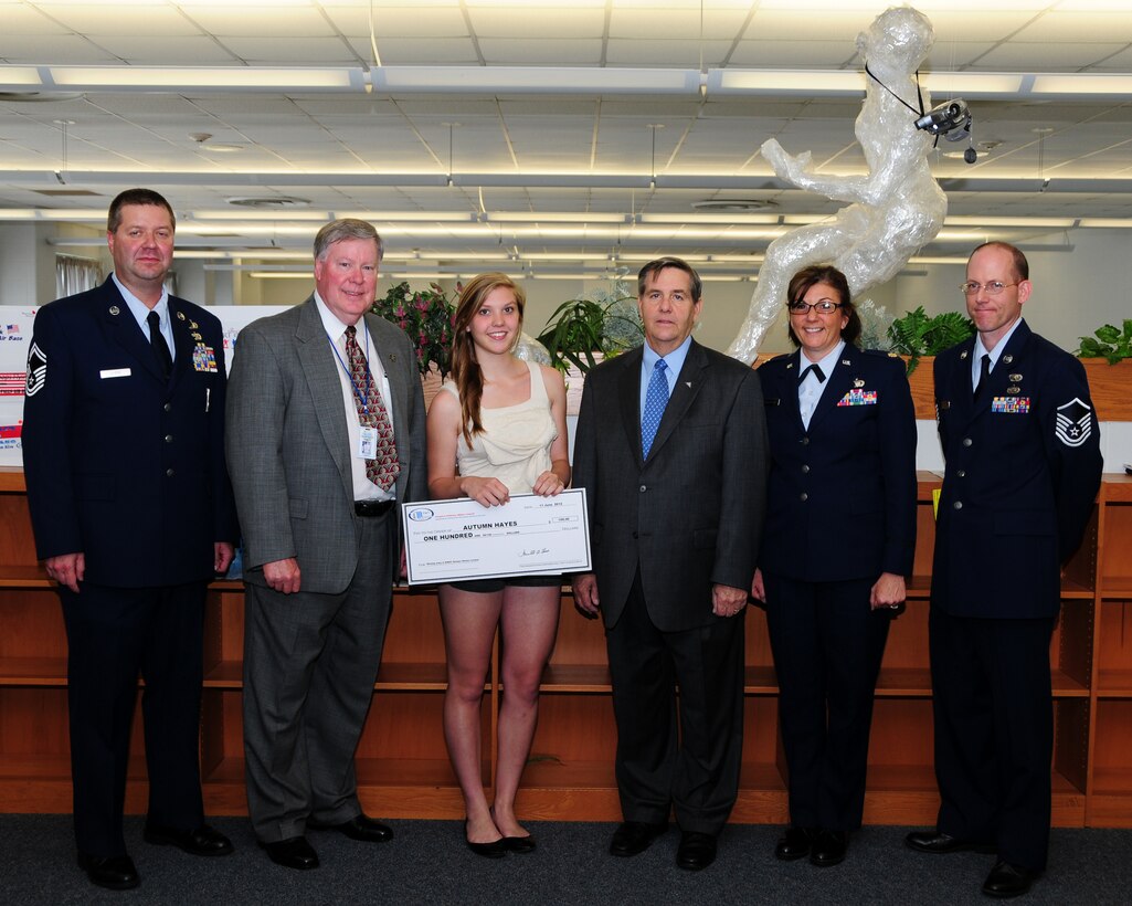 Niagara Wheatfield High School art student Autumn Hayes displays her reward for her 'Keeping Freedom Alive' design.  Hayes' submission won first place in a Niagara Military Affairs Council sponsored design contest.  Her design will be featured on the next NIMAC bumper sticker to be seen around the area.  Representatives from the 914th and 107th Airlift Wings and Niagara County Legislature were also on hand during the NIMAC award presentation June 11, 2012 in the Niagara Wheatfield H.S.  Pictured (L to R) Senior Master Raymond Lloyd, 107 AW Public Affairs; Mr. David Godfrey, Niagara County Legislature; Ms. Autumn Hayes, Niagara Wheatfield H.S.; Mr. Merrell Lane, NIMAC Chairman; Maj. Andrea Pitruzzella, 914 AW Public Affairs; Master Sgt. Kevin Nichols, 914 AW Public Affairs.  (U.S. Air Force photo by Mr. Peter Borys)