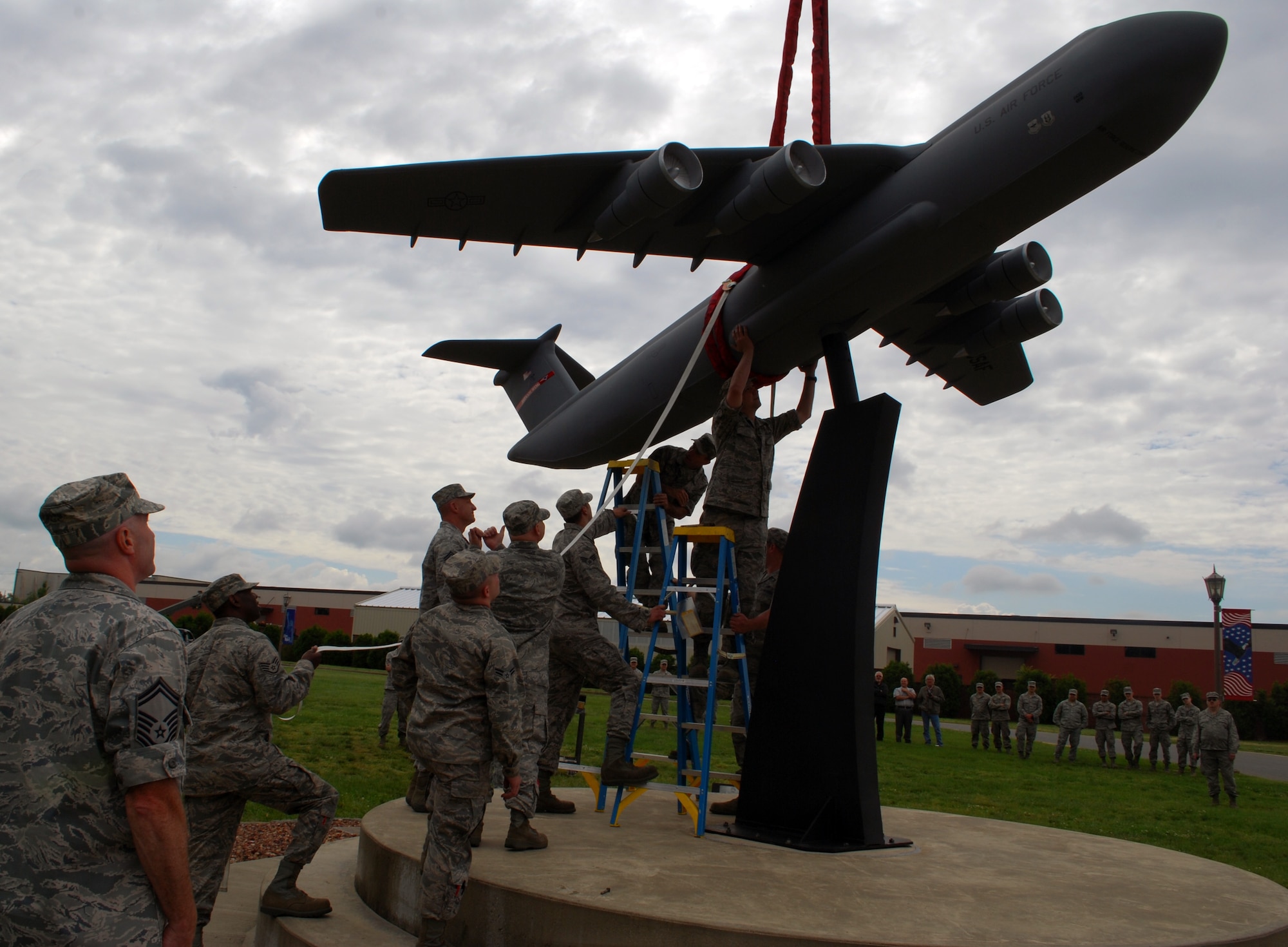 Several 439th Maintenance Squadron Airmen spent several months assembling a 1:12 scale C-5. It replaces the one destroyed by the July 2011 micro burst. Just weeks ahead of the August Great New England Air Show, crews assisted maintenance Airmen with placing the 1,000-pound aluminum model on its pedestal at Westover on June 6. (U.S. Air Force photo/MSgt. Andrew Biscoe)