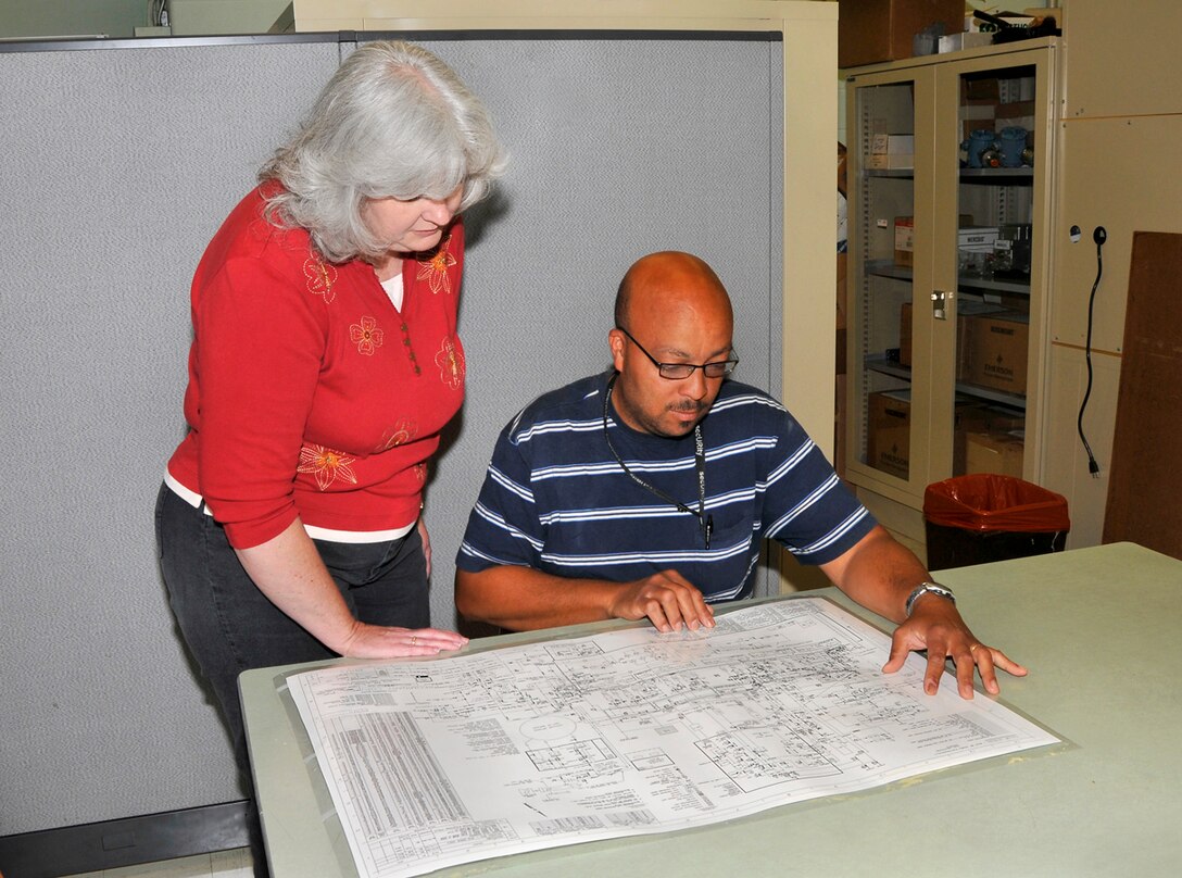Left to right, Marilyn Graves, ATA project manager for the V-plant control systems upgrade, and Mitch Turrentine, an ATA flight systems plant operations engineer, review a V-plant drawing in preparation for the upgrade project. (Photo by Jacqueline Cowan)