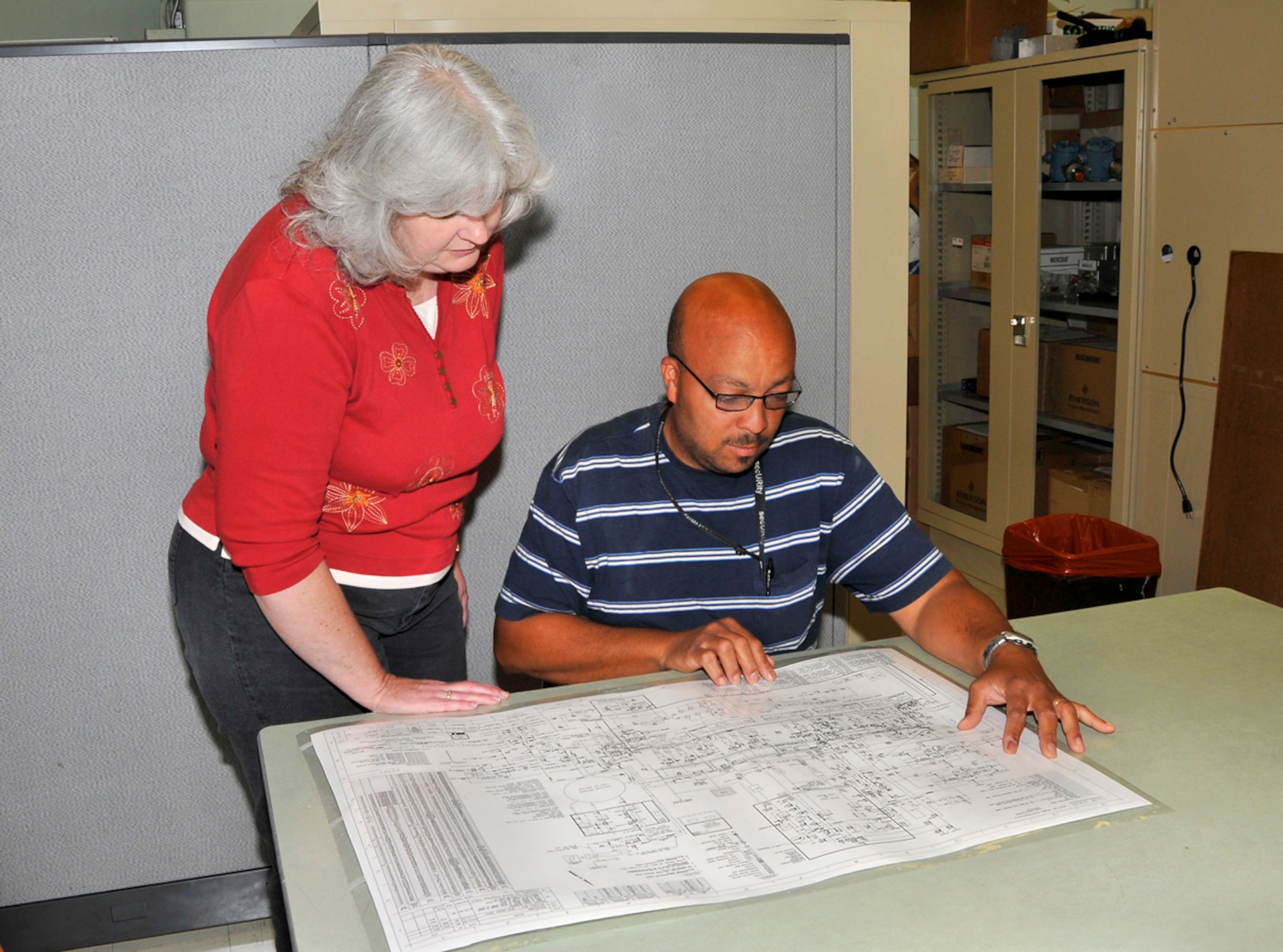 Left to right, Marilyn Graves, ATA project manager for the V-plant control systems upgrade, and Mitch Turrentine, an ATA flight systems plant operations engineer, review a V-plant drawing in preparation for the upgrade project. (Photo by Jacqueline Cowan)
