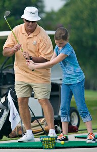 Brian Cannon, a teaching Pro at Joint Base San Antonio - Randolph Oaks Golf Course instructs Delaney Shick on her backswing during the annual Junior Golf Clinic, June 13 at JBSA-Randolph, Texas. (U.S. Air Force photo by Benjamin Faske)
