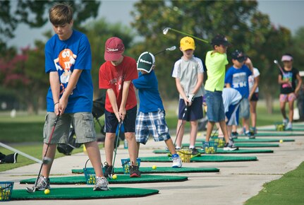 Participants of the annual Junior Golf Clinic at Joint Base San Antonio-Randolph Oaks Golf Course line the driving range to practice their swing at, JBSA-Randolph, Texas. (U.S. Air Force photo by Benjamin Faske)