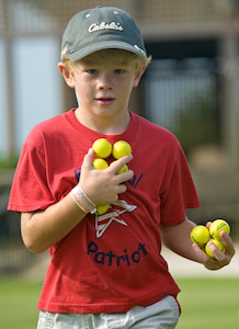 Luke Fisher gathers golf balls from the putting green June 13 at the annual Junior Golf Clinic at Joint Base San Antonio-Randolph Oaks Golf Course, JBSA-Randolph, Texas. (U.S. Air Force photo by Benjamin Faske)