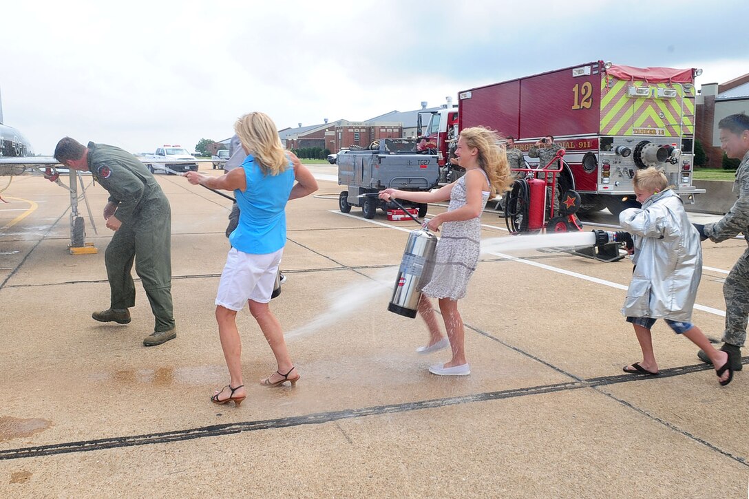 Joni, left, wife of U.S. Air Force Col. Kevin Mastin, 1st Fighter Wing vice commander, and his children, Ashley and Travis, soak him with water during his final flight at Langley Air Force Base, Va., June 13, 2012. Mastin and his family are relocating to Washington state for his next assignment. (U.S. Air Force photo by Staff Sgt. Ashley Hawkins/Released)