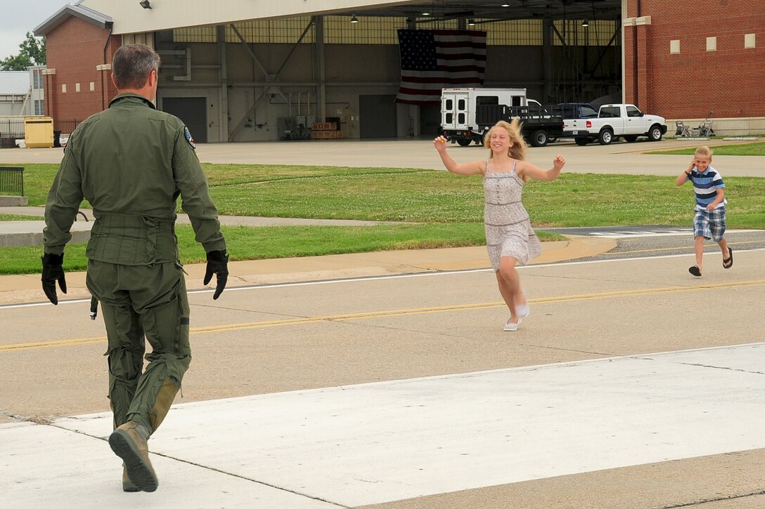 U.S. Air Force Col. Kevin Mastin, 1st Fighter Wing vice commander, greets his children before his final flight ceremony at Langley Air Force Base, Va., June 13, 2012. After serving two years as the vice commander, Mastin will move on to a new assignment in Washington state. (U.S. Air Force photo by Staff Sgt. Ashley Hawkins/Released)