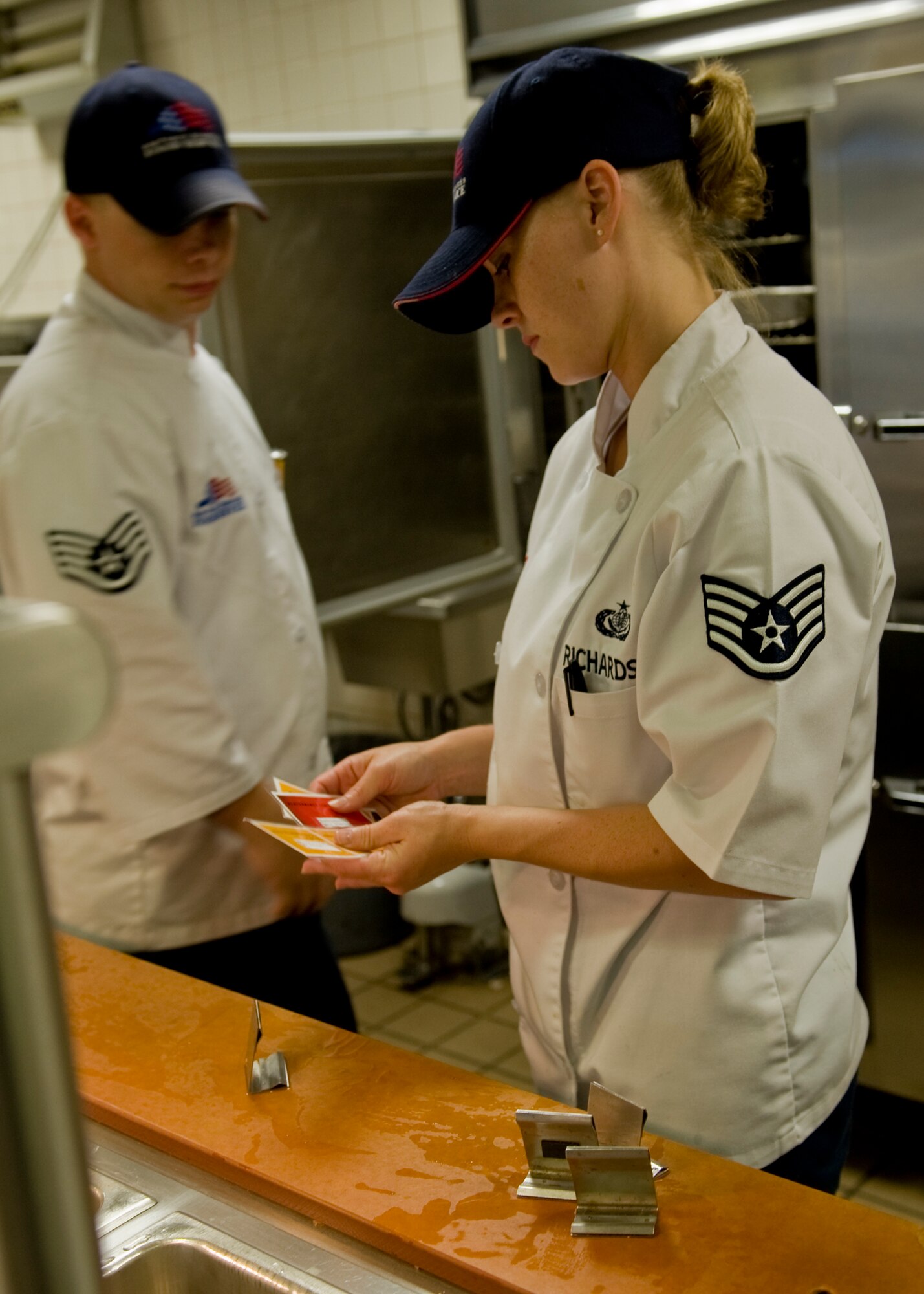 Staff Sgt. Dustin McBroom, left, and Staff Sgt. Angela Richardson, right, 7th Force Support Squadron, inspect menu tags from the main line after lunch service ended at the dining facility June 13, 2012, at Dyess Air Force Base, Texas. The Air Force’s “Go For Green” nutrition education program was initiated to provide visual cues to help Airmen quickly identify the menu items that are most nutritious and have a positive impact on an Airman’s performance.  (U.S. Air Force photo by Roy Utley/Released)